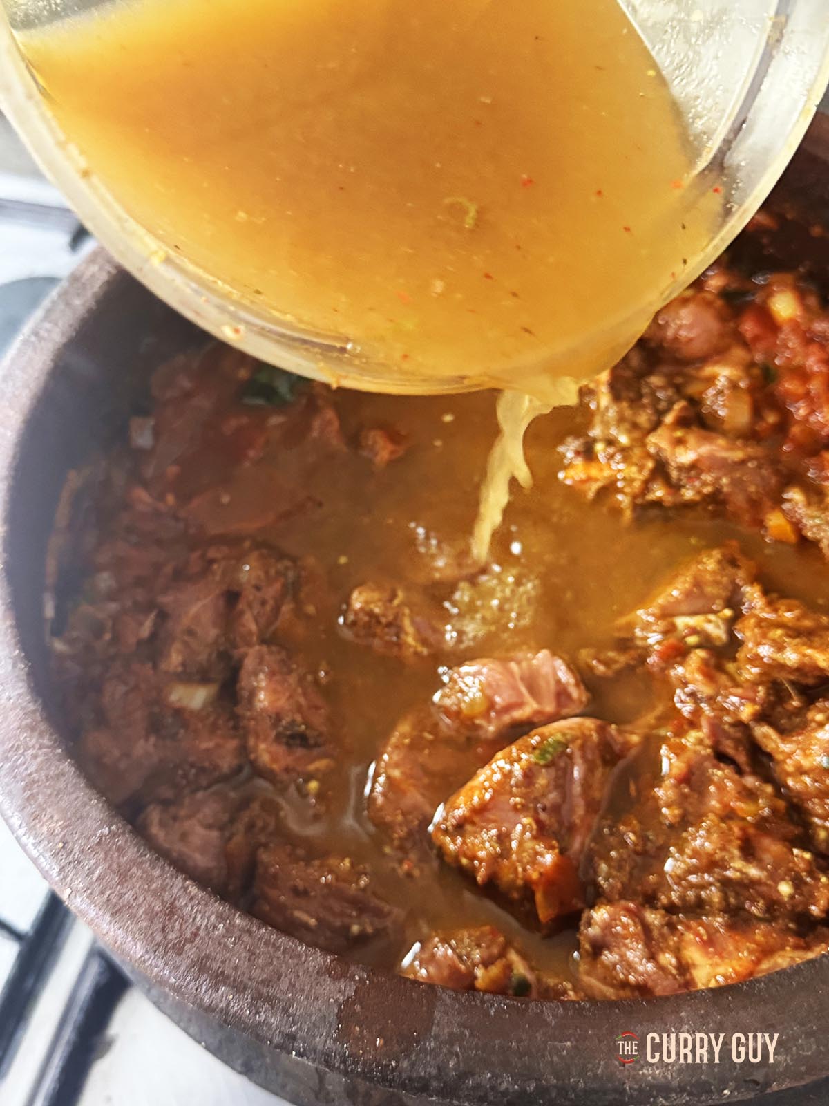 Adding water to the curry.