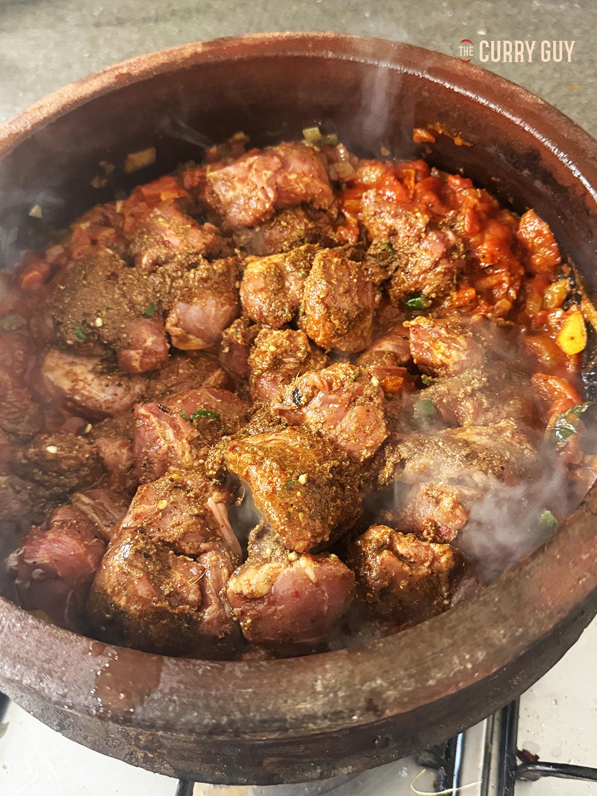 Adding the marinated meat to the pot.