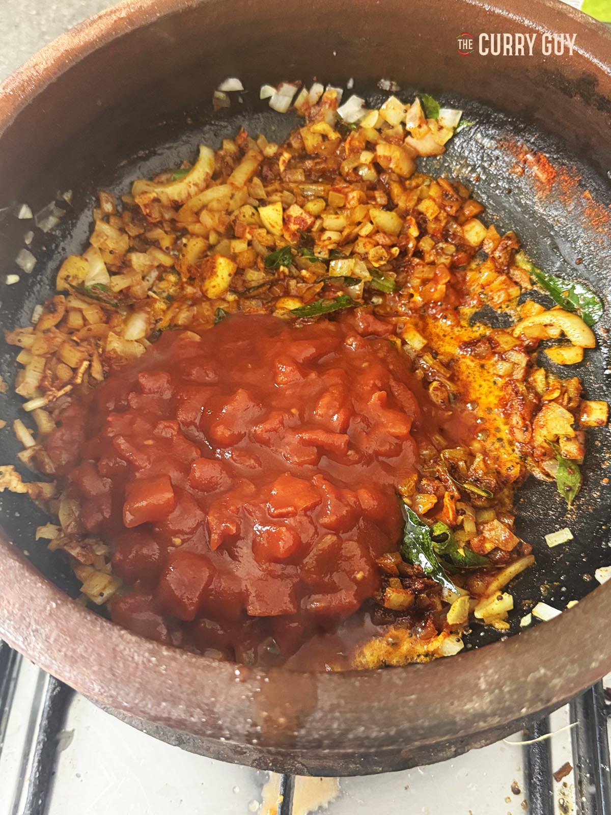 Adding the chopped tomatoes to the pan.