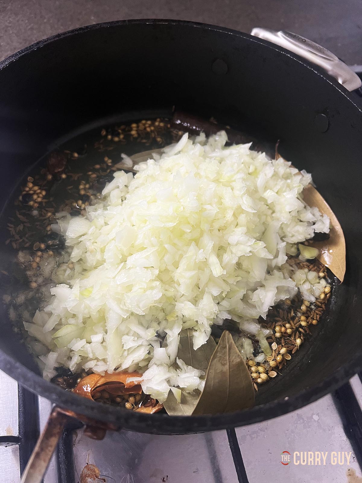 Adding onions to the pan.