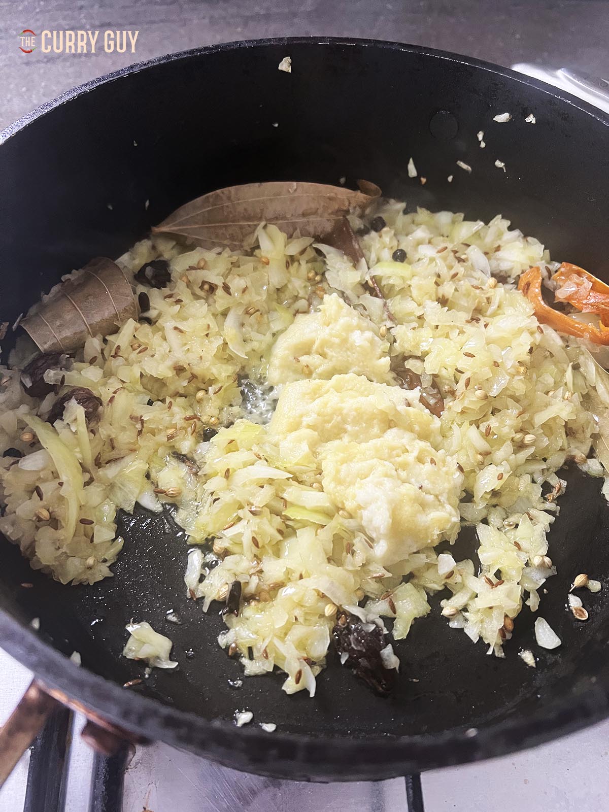 Frying the onions to soften and adding the garlic and ginger paste.