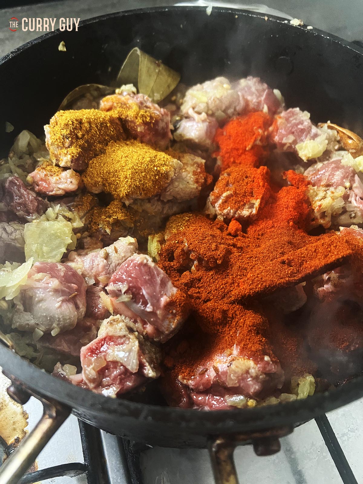 Adding the ground spices to the pan.