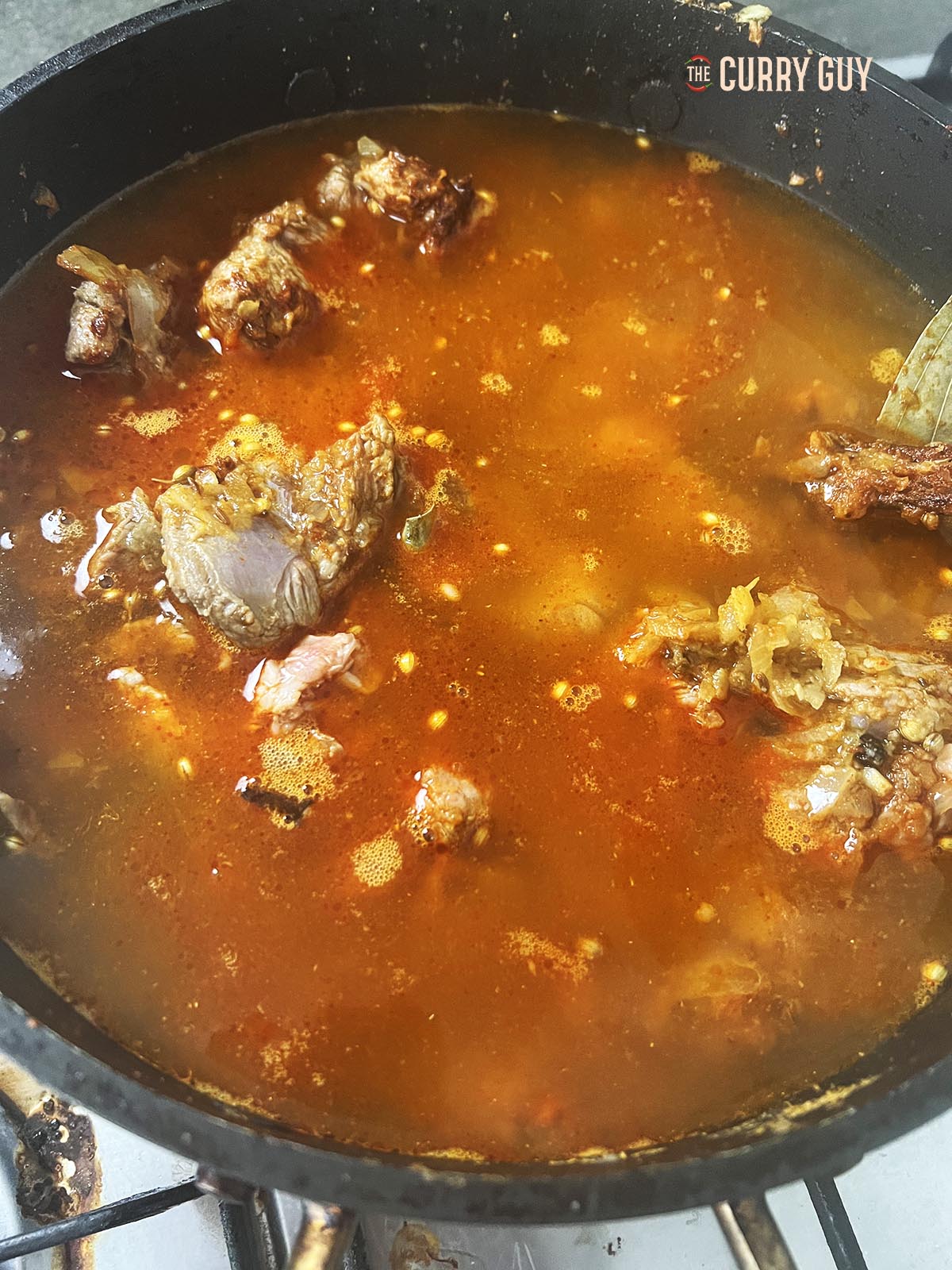 Adding water to cover the meat and simmer.