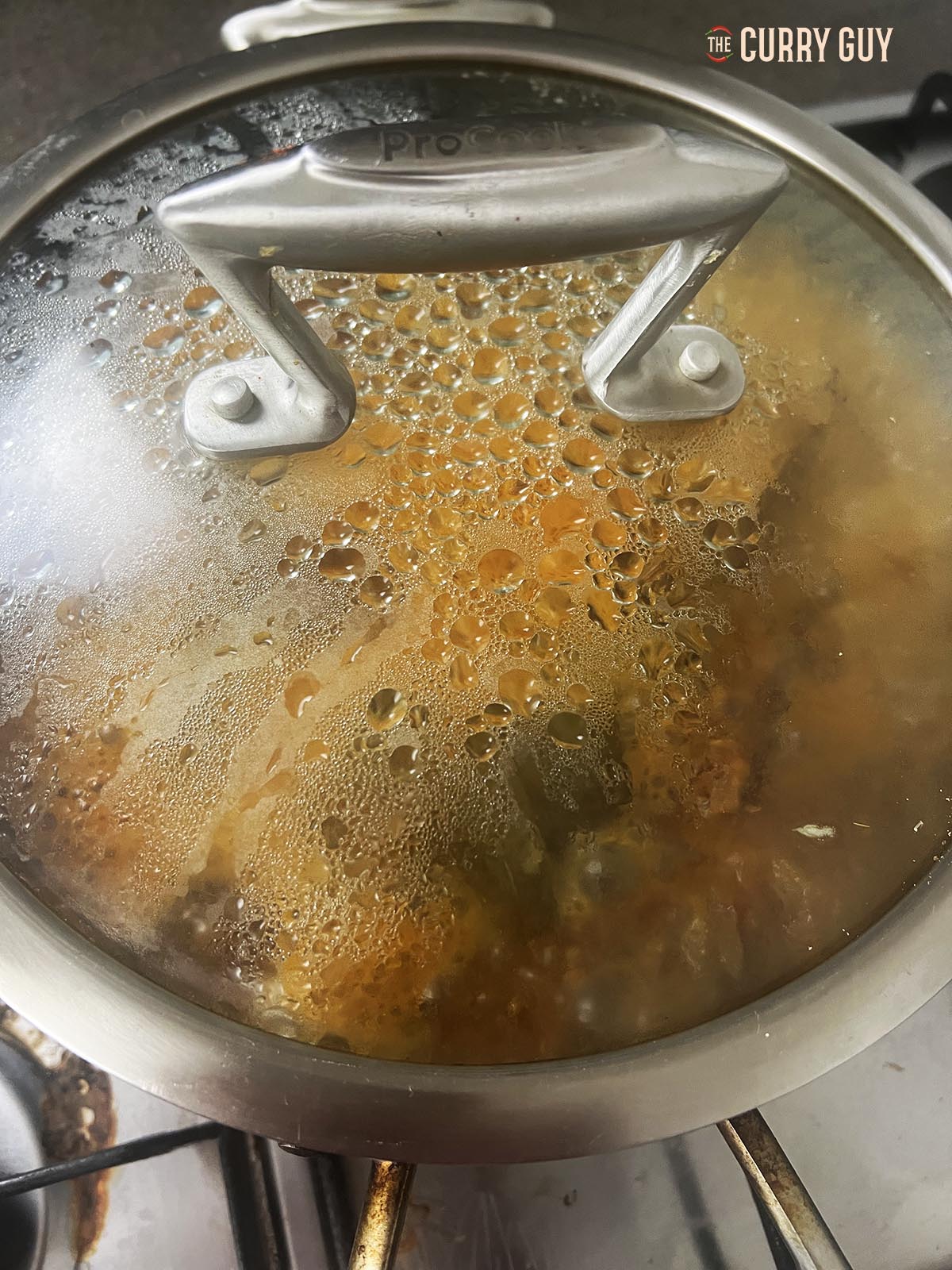 Simmering the meat in a covered pan.