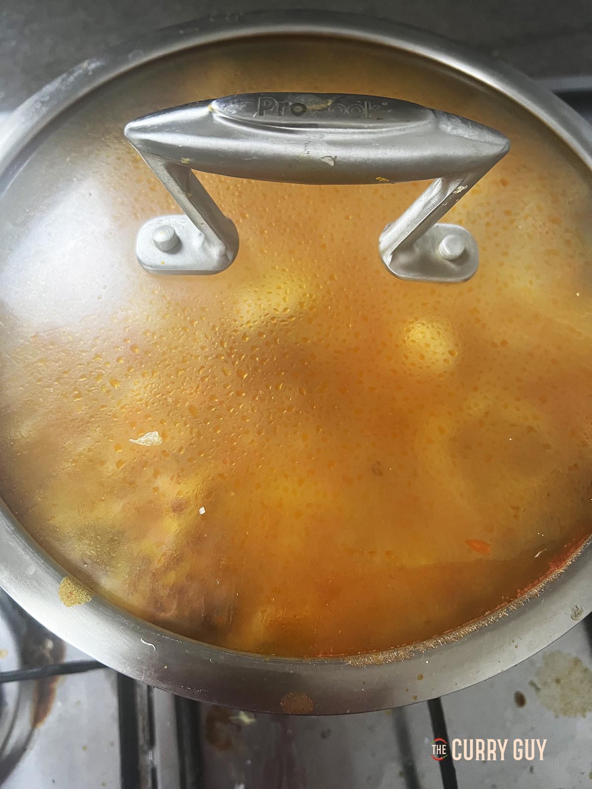 Simmering the chicken in a covered pan.