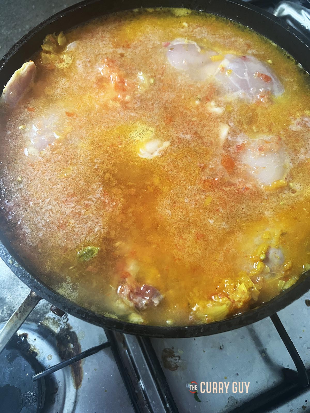 Adding water to cover the chicken in the pan.