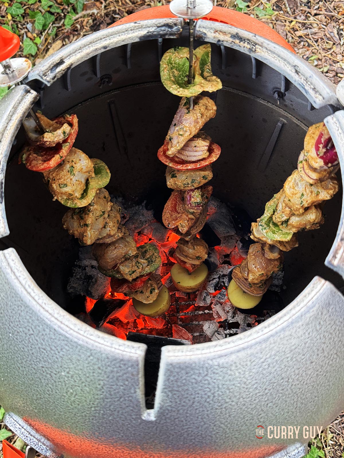 The monkfish on skewers cooking in a tandoor oven.