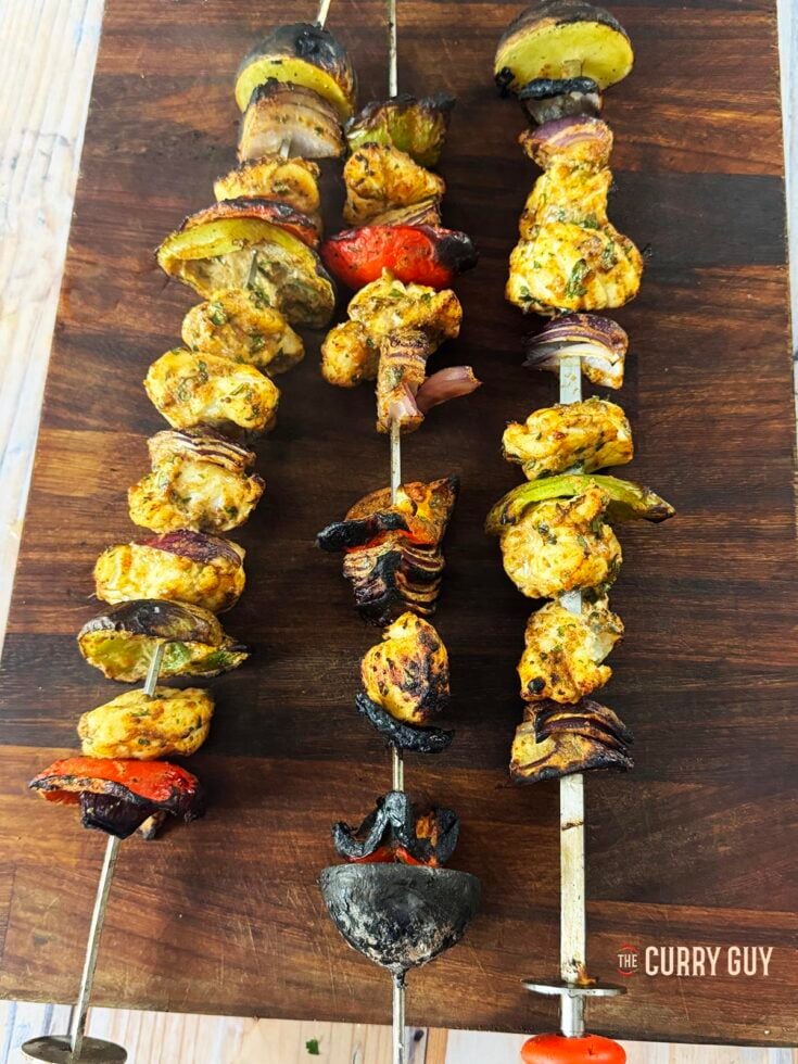Grilled monkfish on skewers on a serving platter.