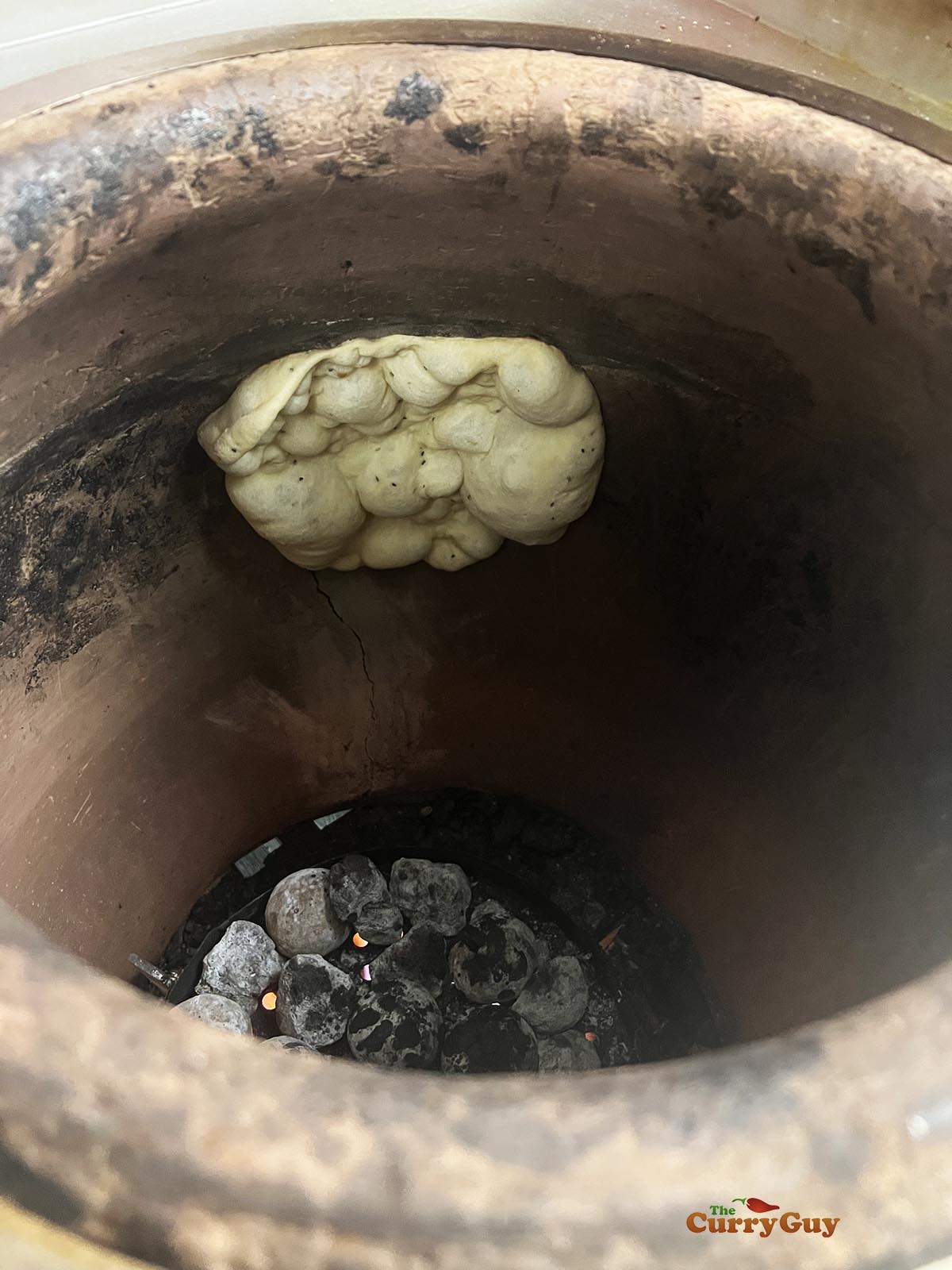 naan cooking in a tandoor oven