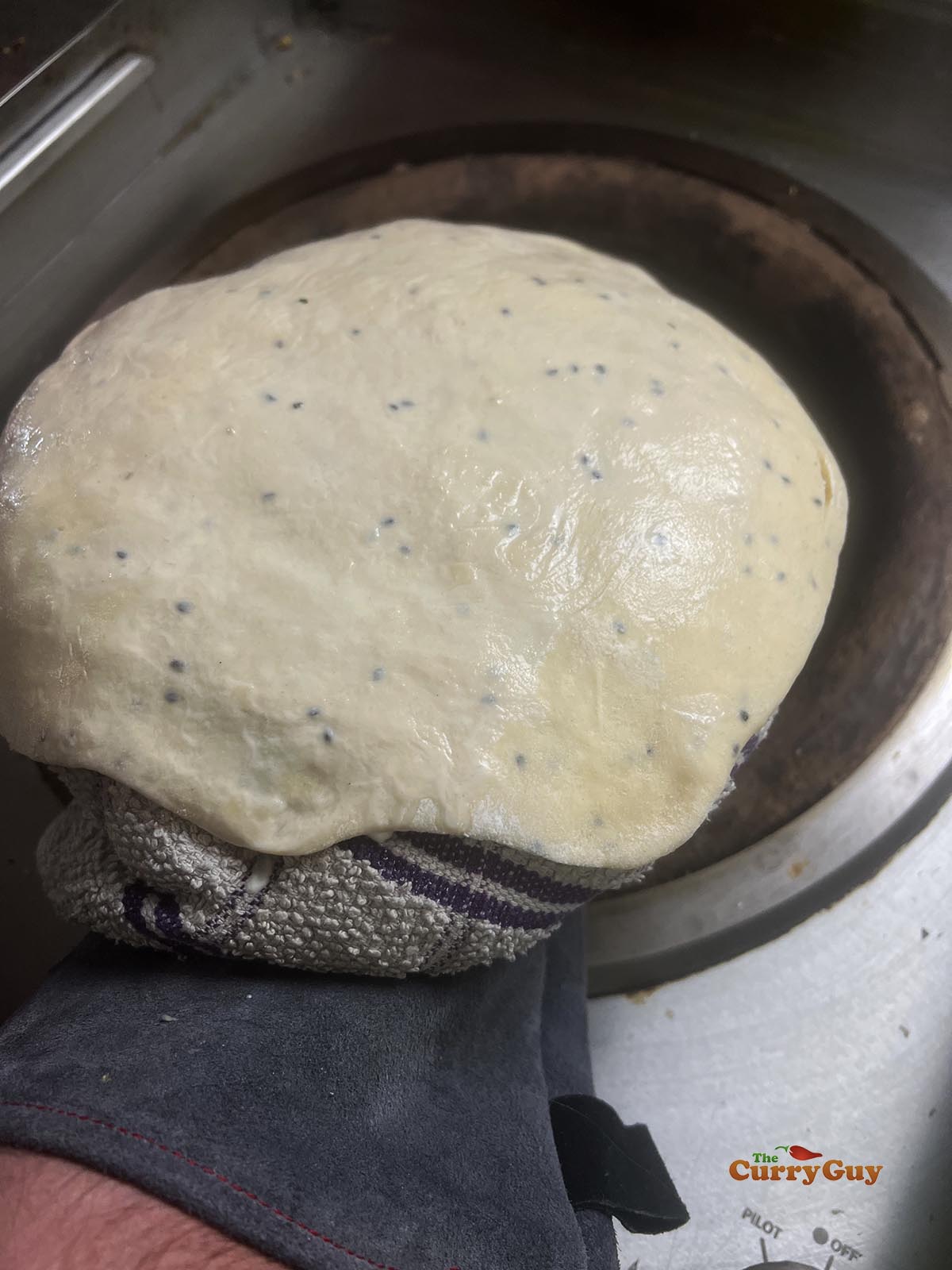 Dampened naan going into the tandoor oven