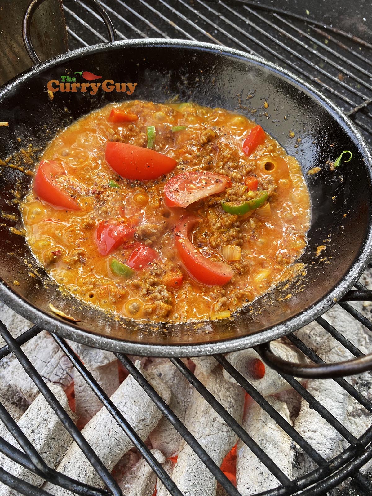 Adding tomato to sauce. 