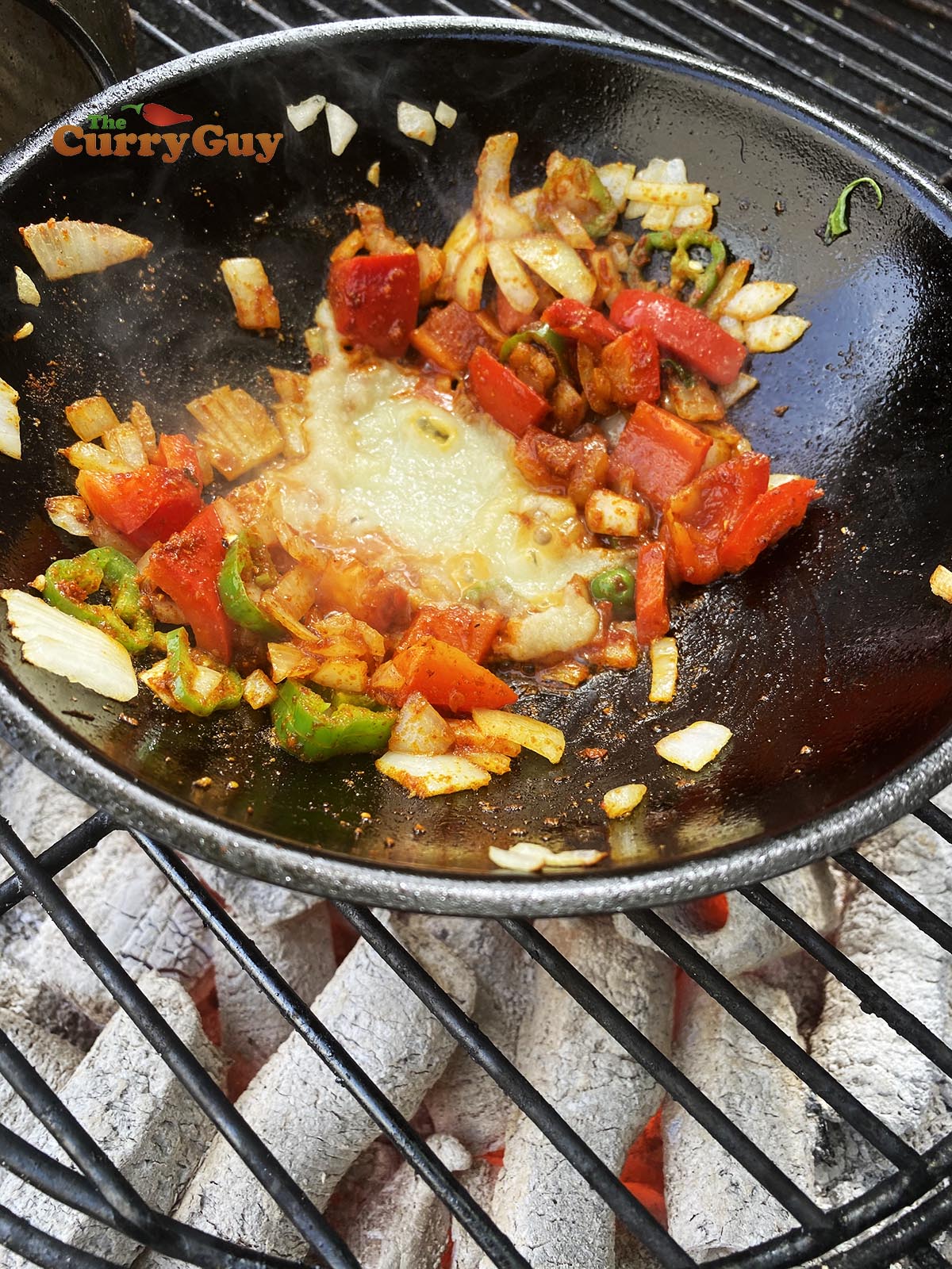 Adding garlic and ginger paste to curry