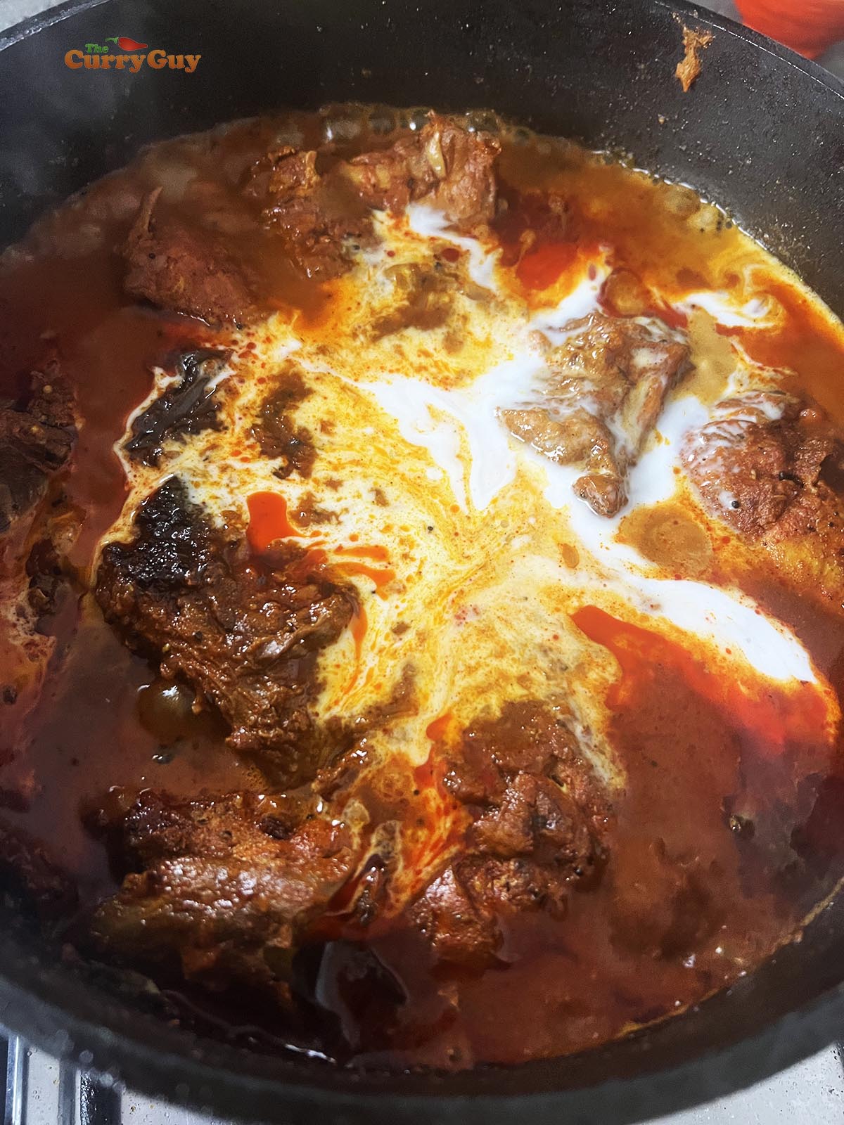 Stirring in the coconut milk and tamarind concentrate.