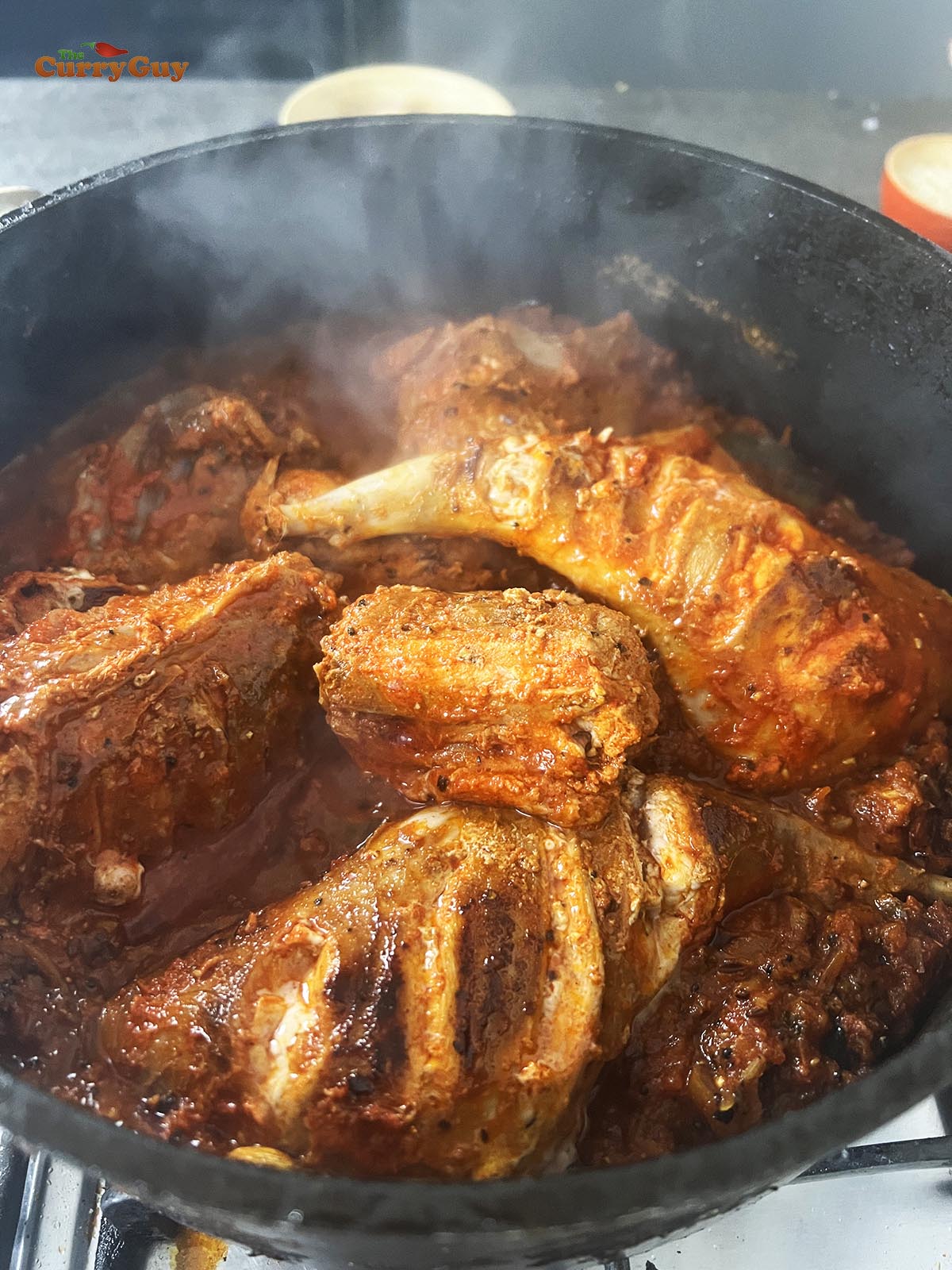 Returning the fried rabbit to the pan and stirring it into the onion and spice mixture.