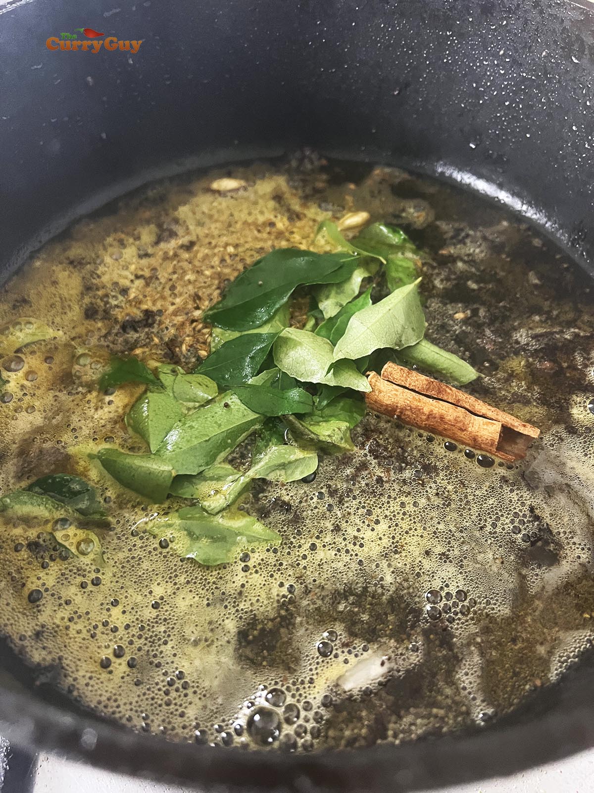 Adding whole spices and curry leaves to the pan
