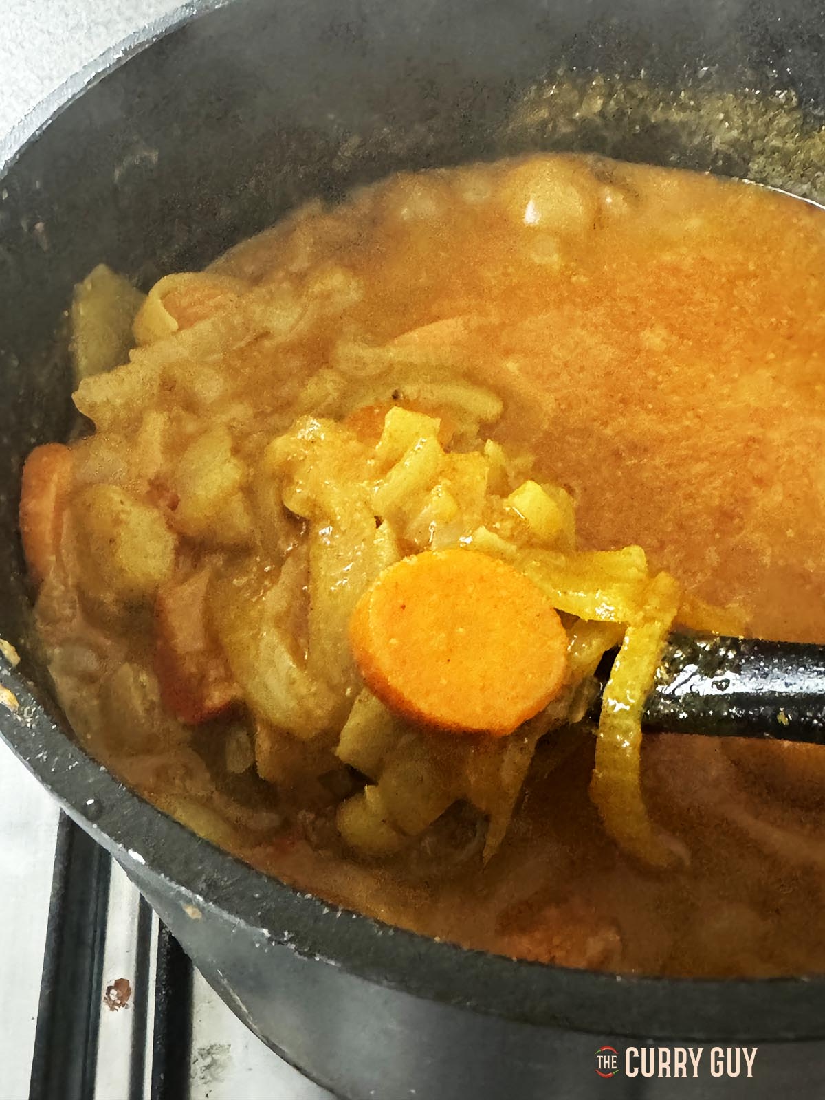 Showing the cooked vegetables in the sauce on a spoon.