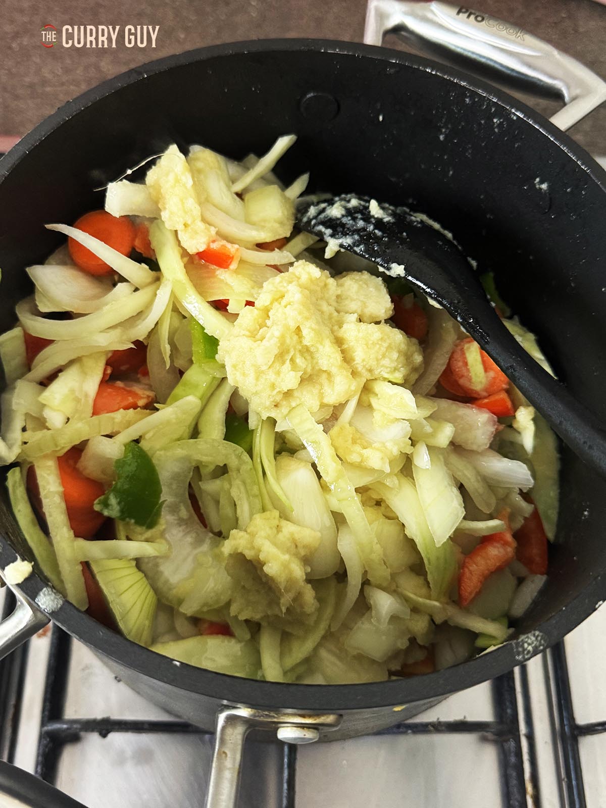 Adding the garlic and ginger paste to the pot.