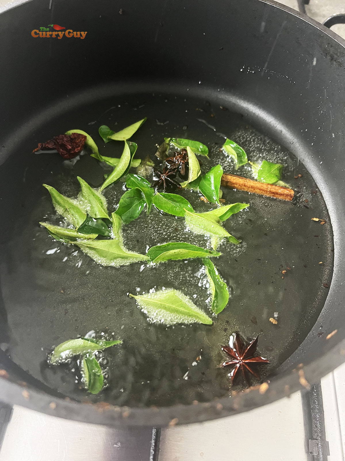 Infusing spices and curry leaves into the oil.