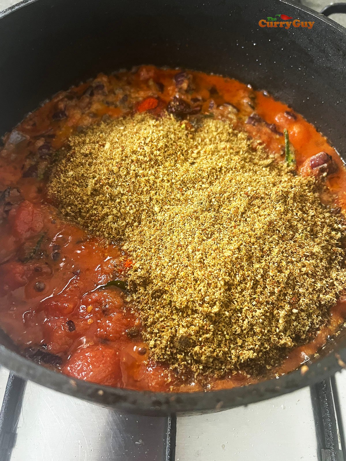 Adding the ground spices and coconut to the sauce.