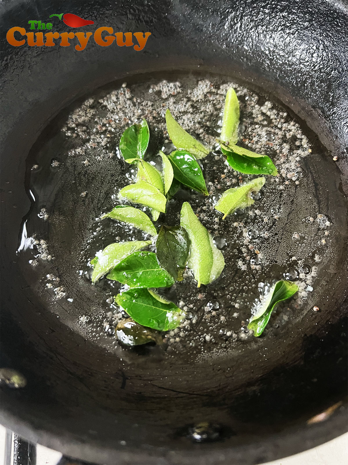 Frying the mustard seeds and curry leaves.