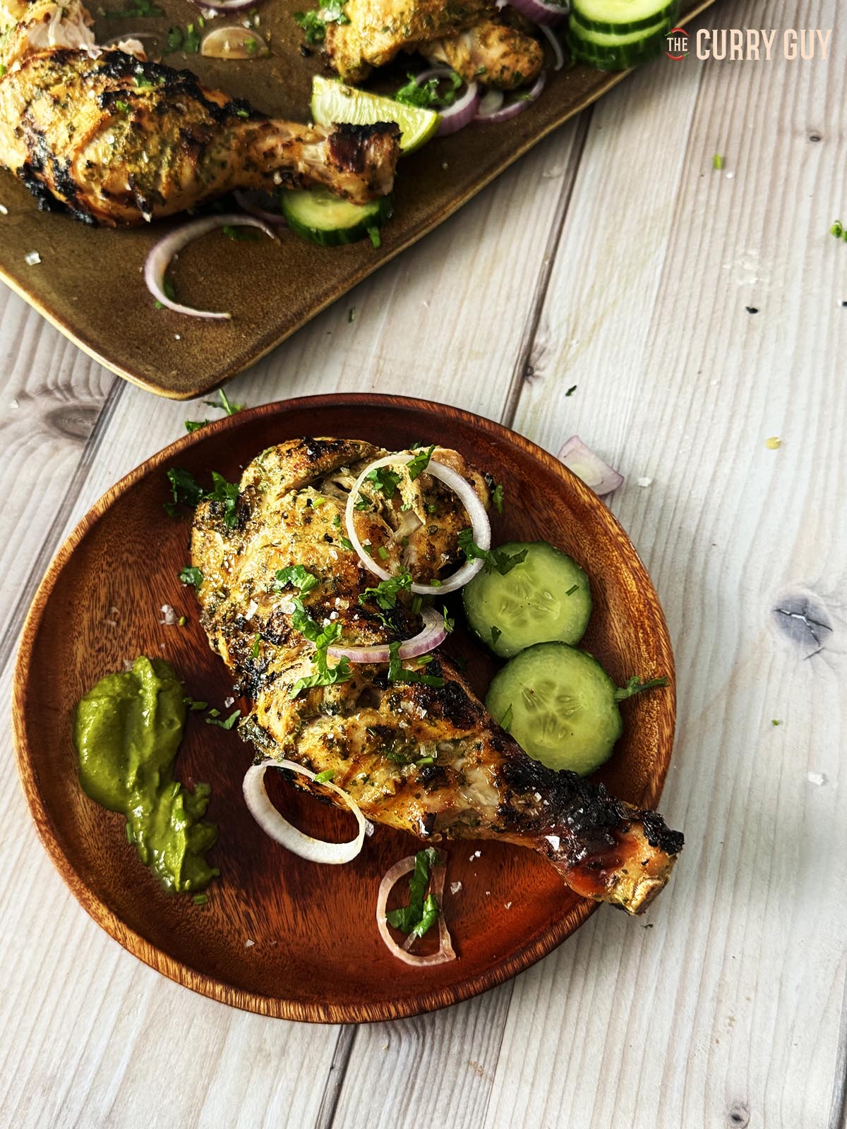 Grilled chicken leg with salad vegetables served on a plate at the table.
