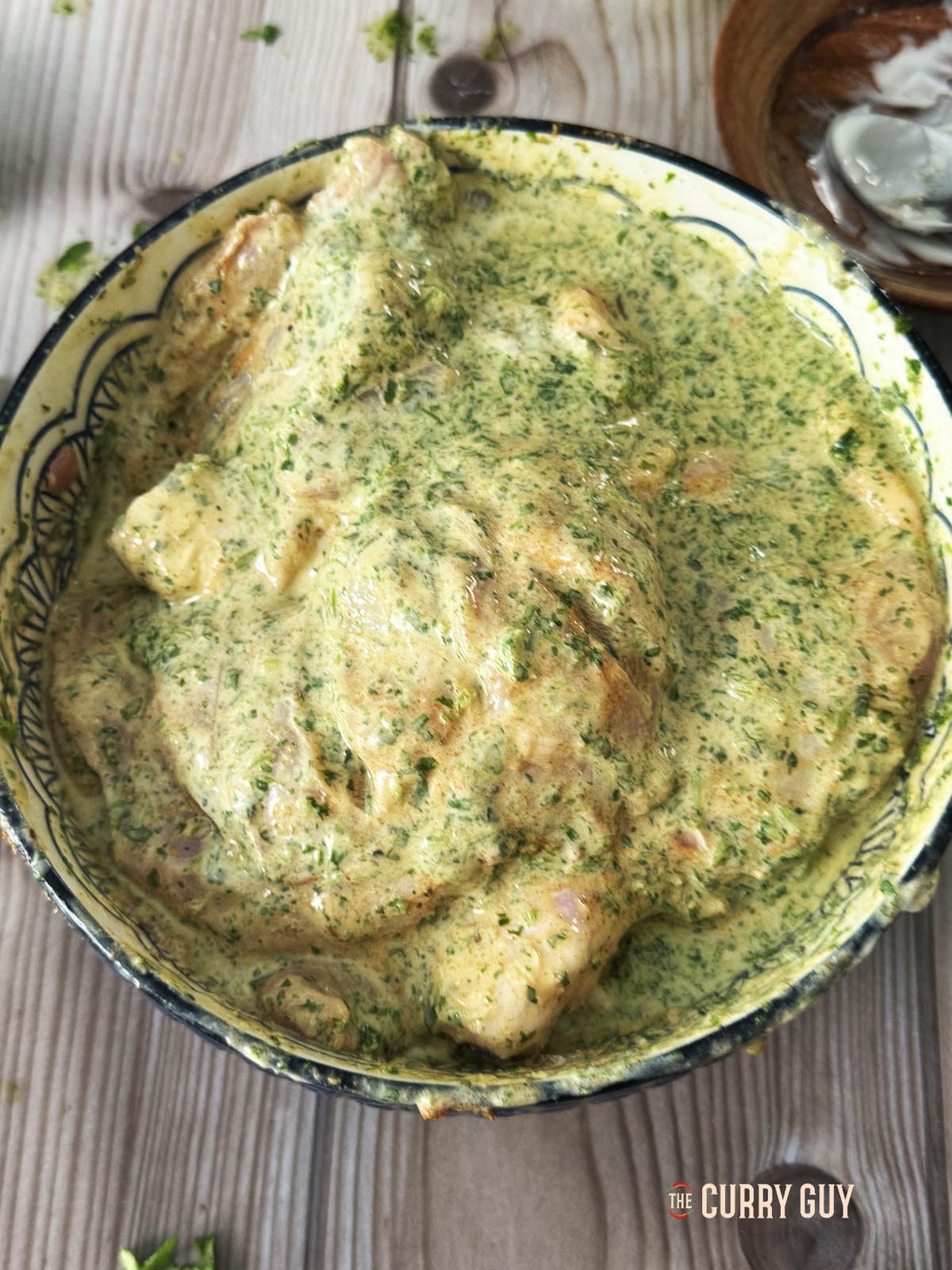 The chicken in a bowl covered with the marinade.
