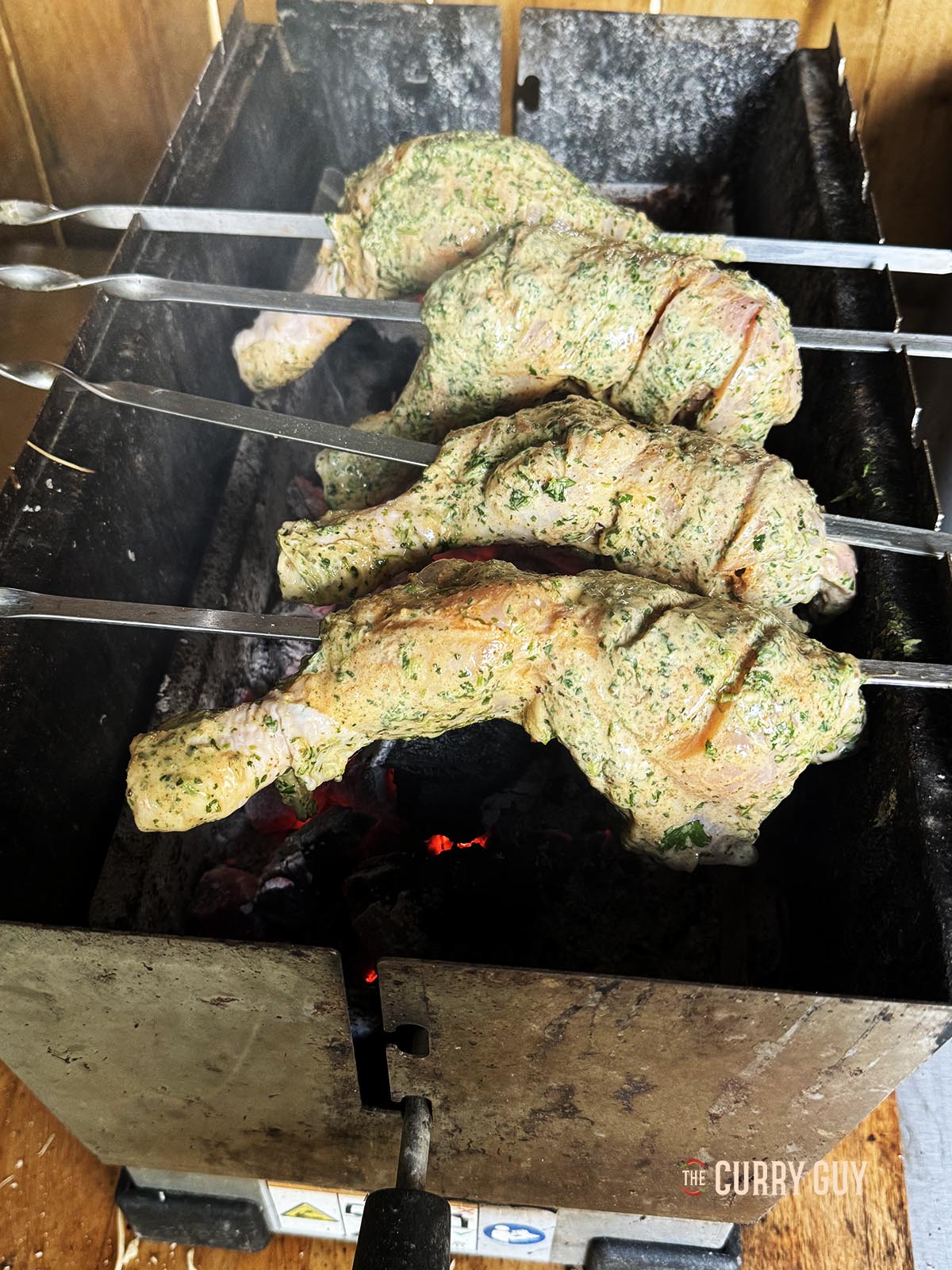 The skewered chicken cooking over the hot coals.