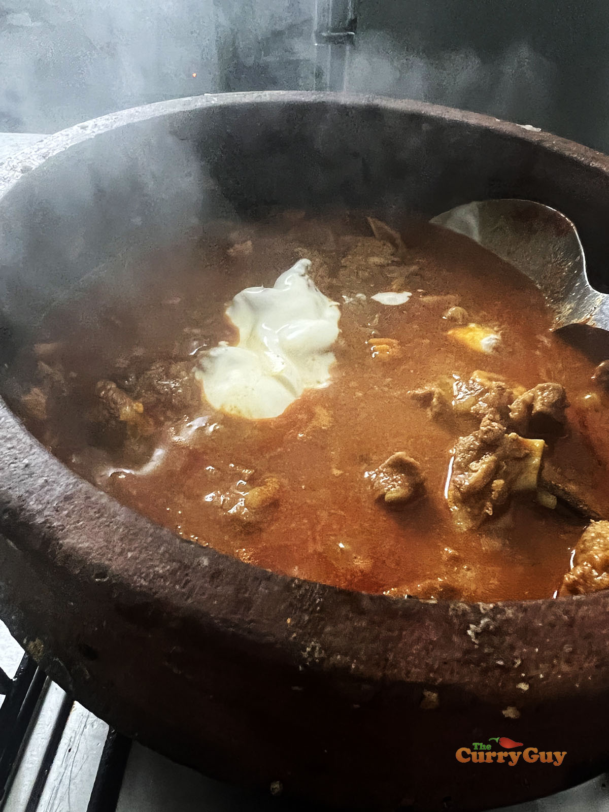 Adding yoghurt to the curry.
