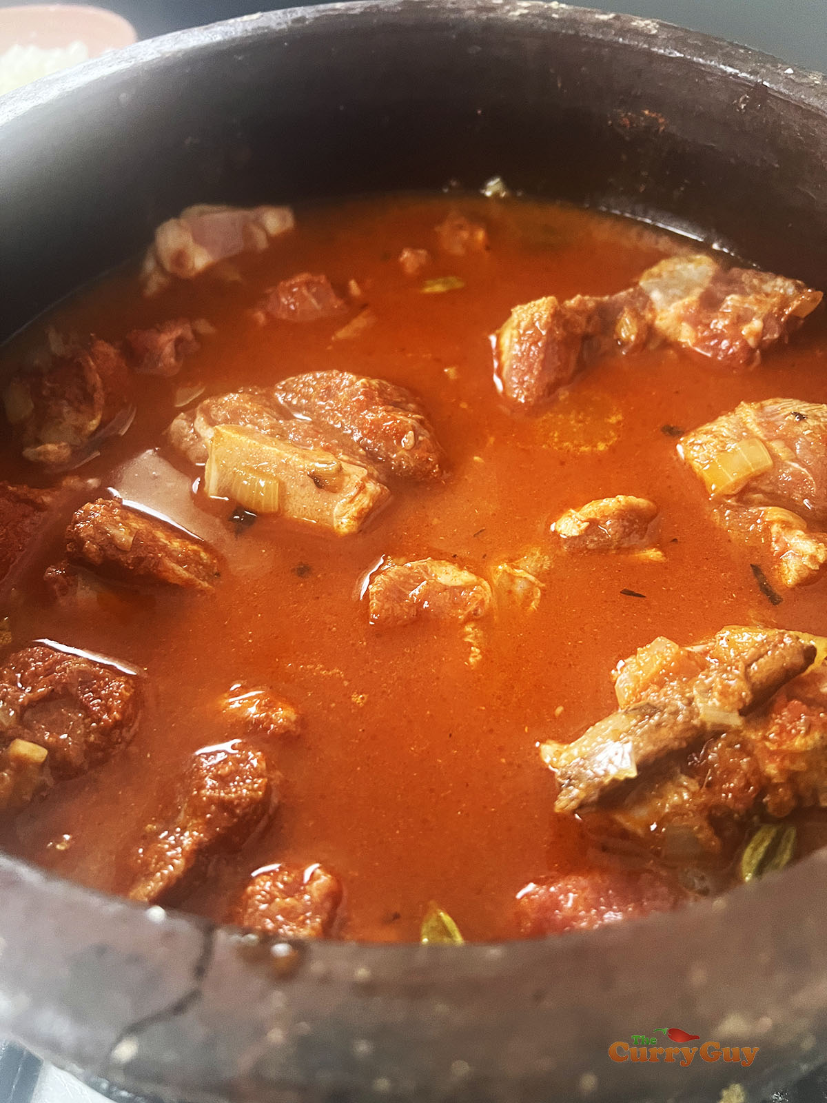 Adding lamb and water to the pan.