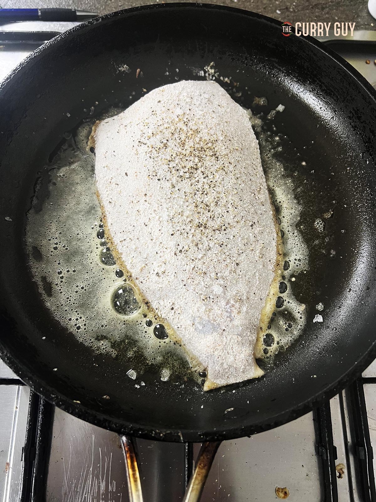 Frying the fish in butter with the dark skin facing down.