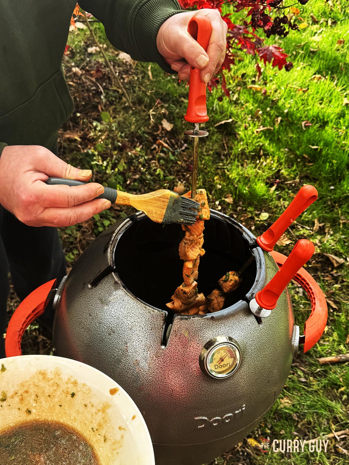 Basting the salmon with the marinade as it cooking.
