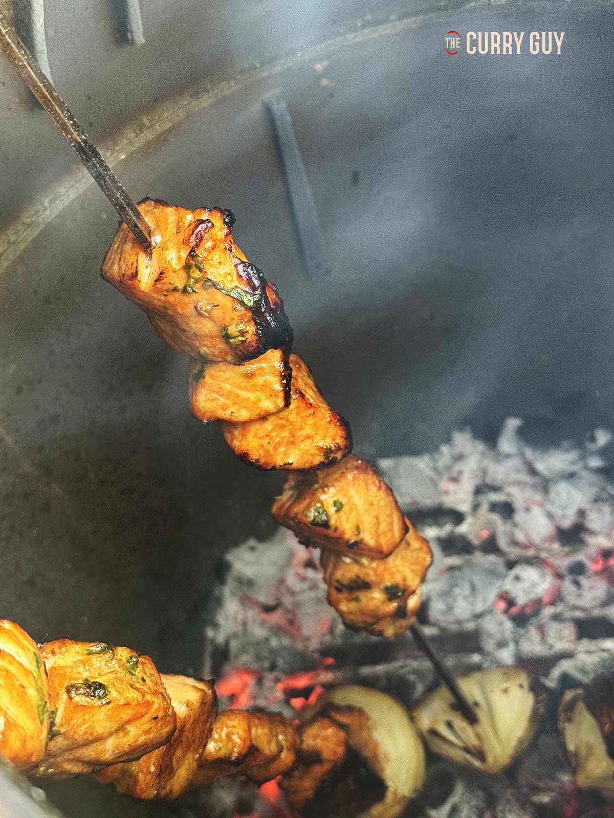 The salmon tikka cooking in a tandoor oven.