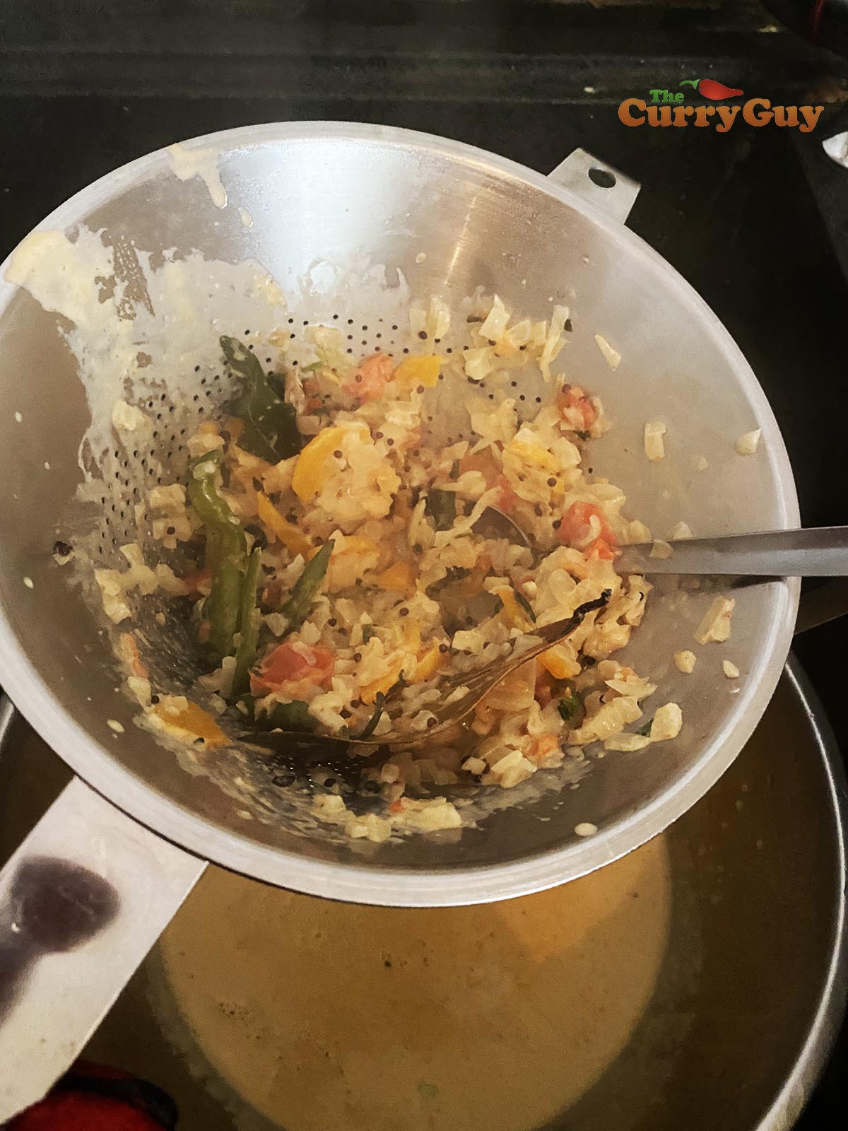 passing sauce through a sieve.