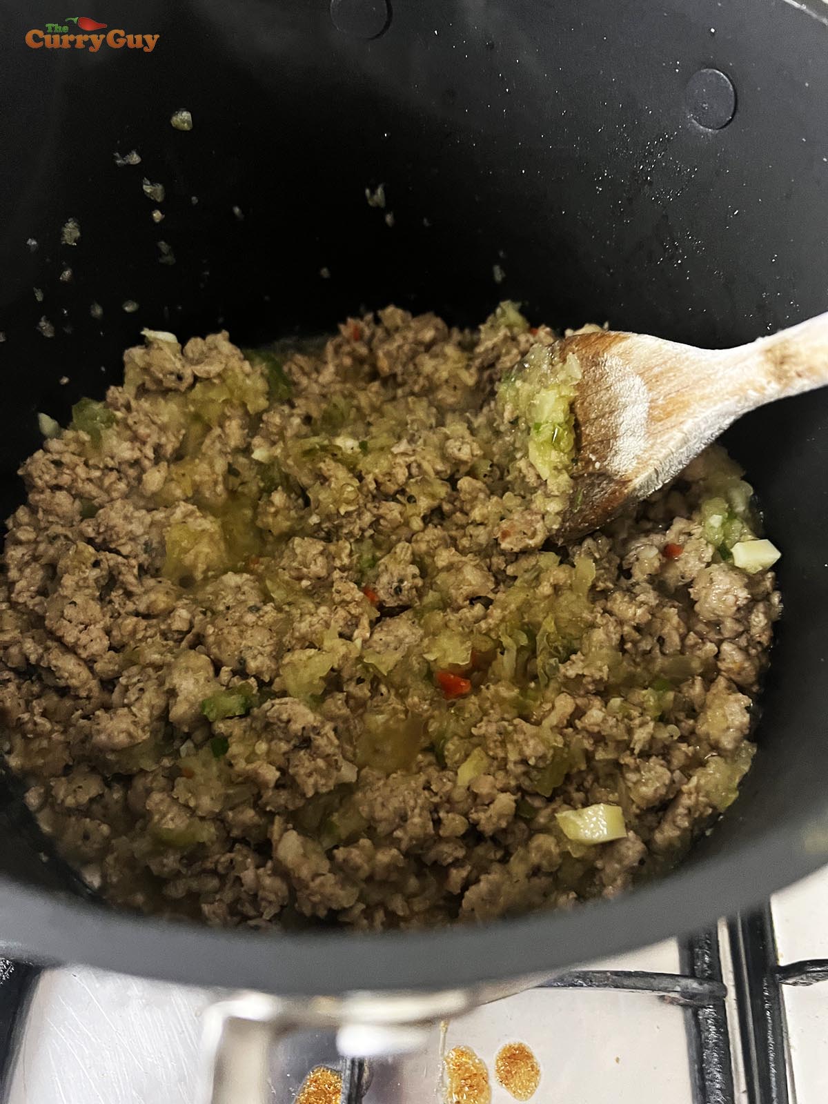 Frying the sausages, onion and green pepper in the pan.