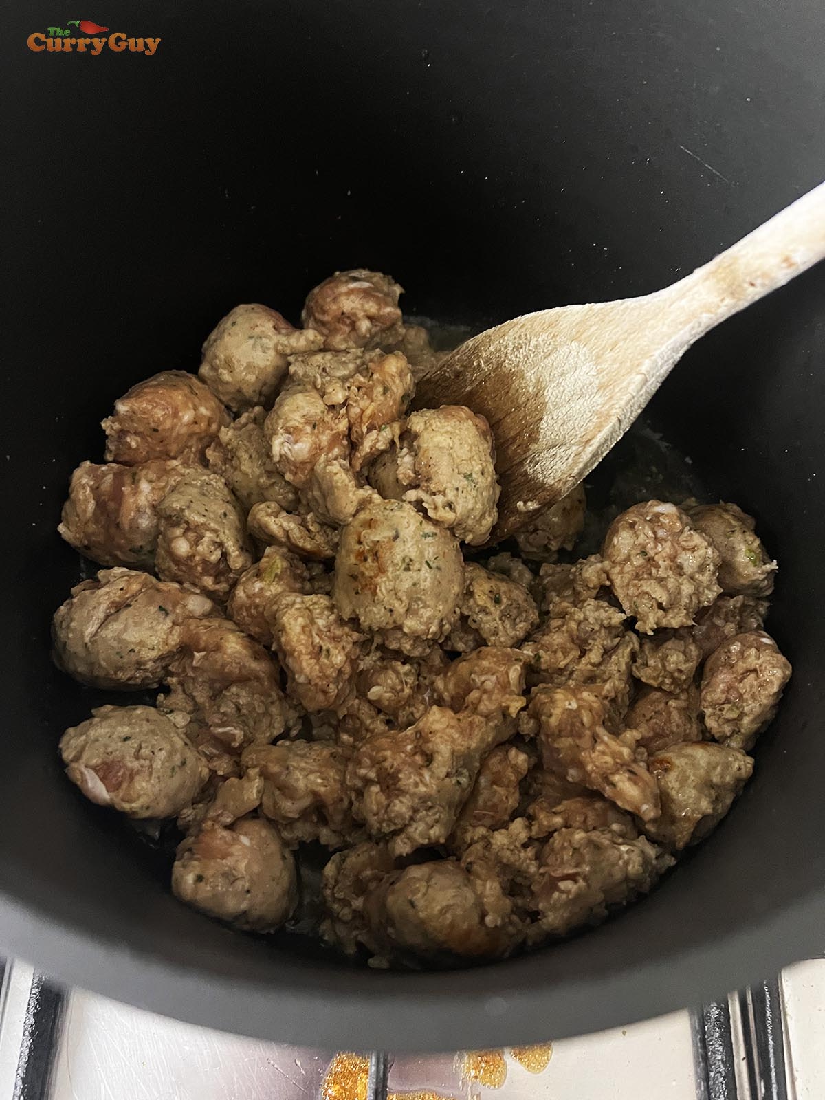 Frying the Italian sausages in a pan.