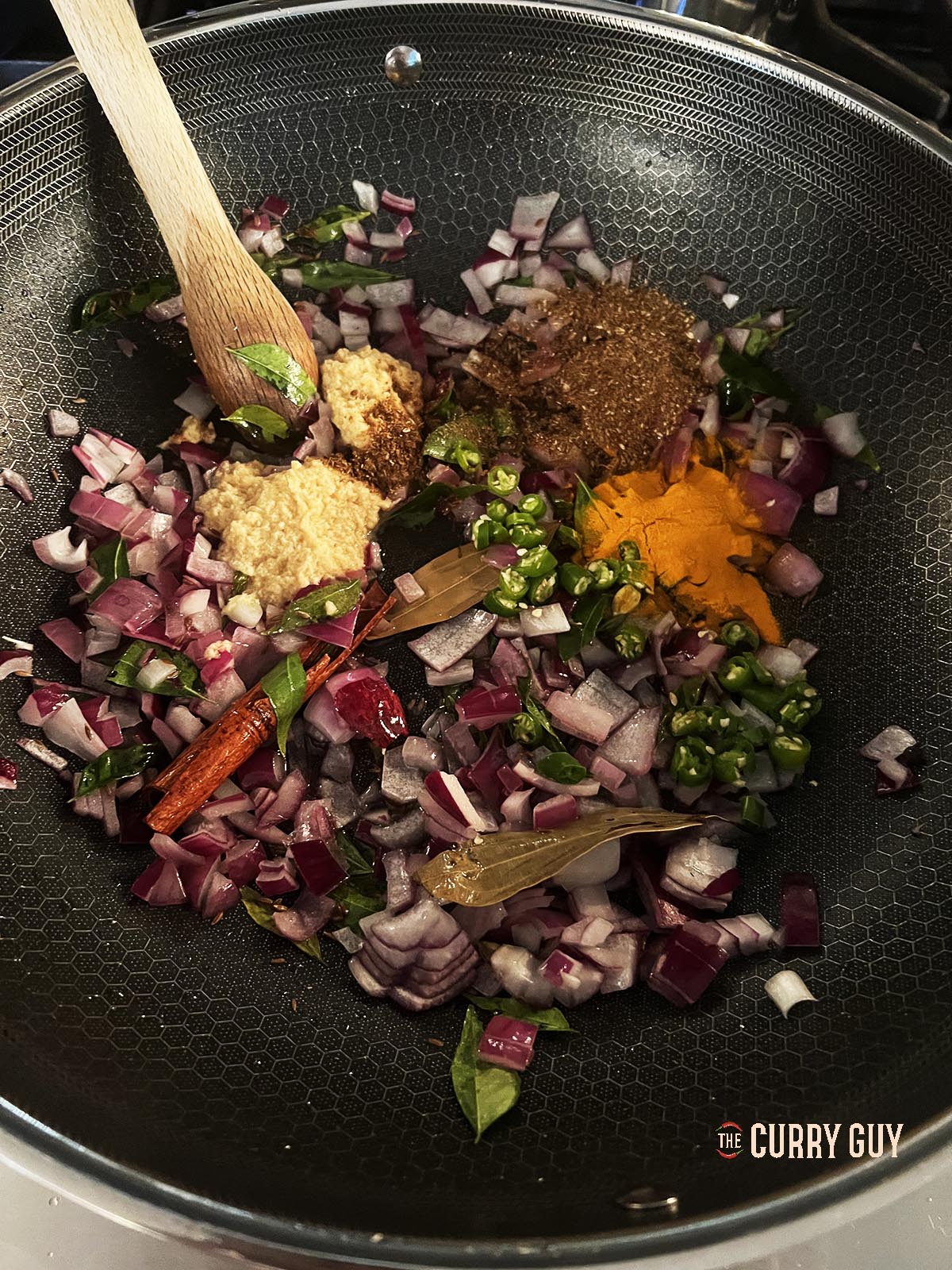 Adding the garlic and ginger paste with the ground spices to the pan.