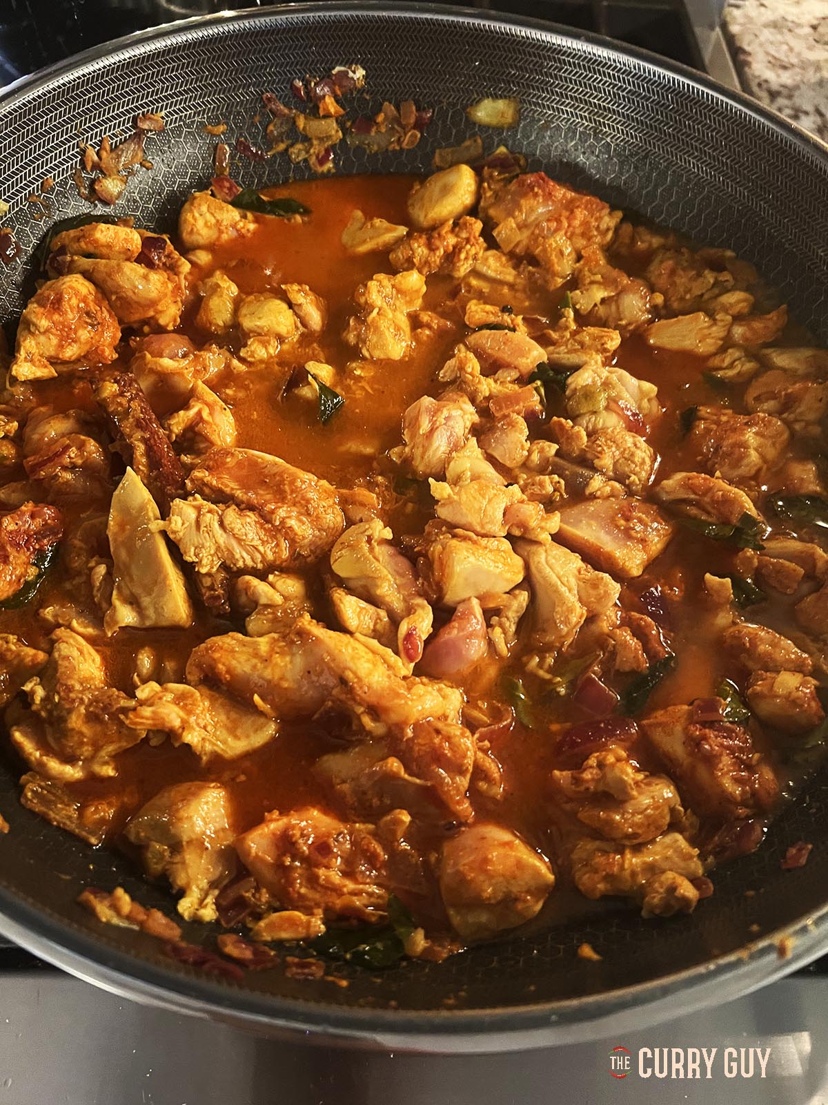 Stirring in the chicken and adding chicken stock.