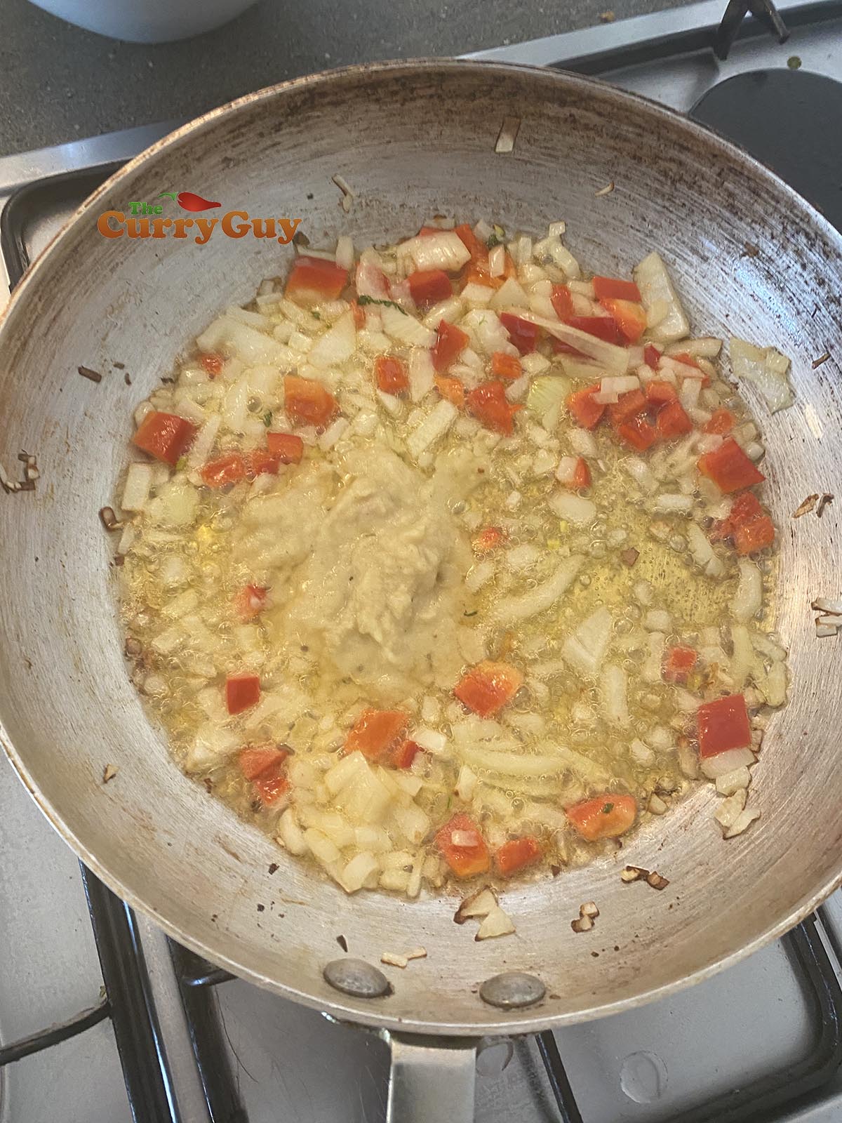 Stirring garlic and ginger paste into the pan