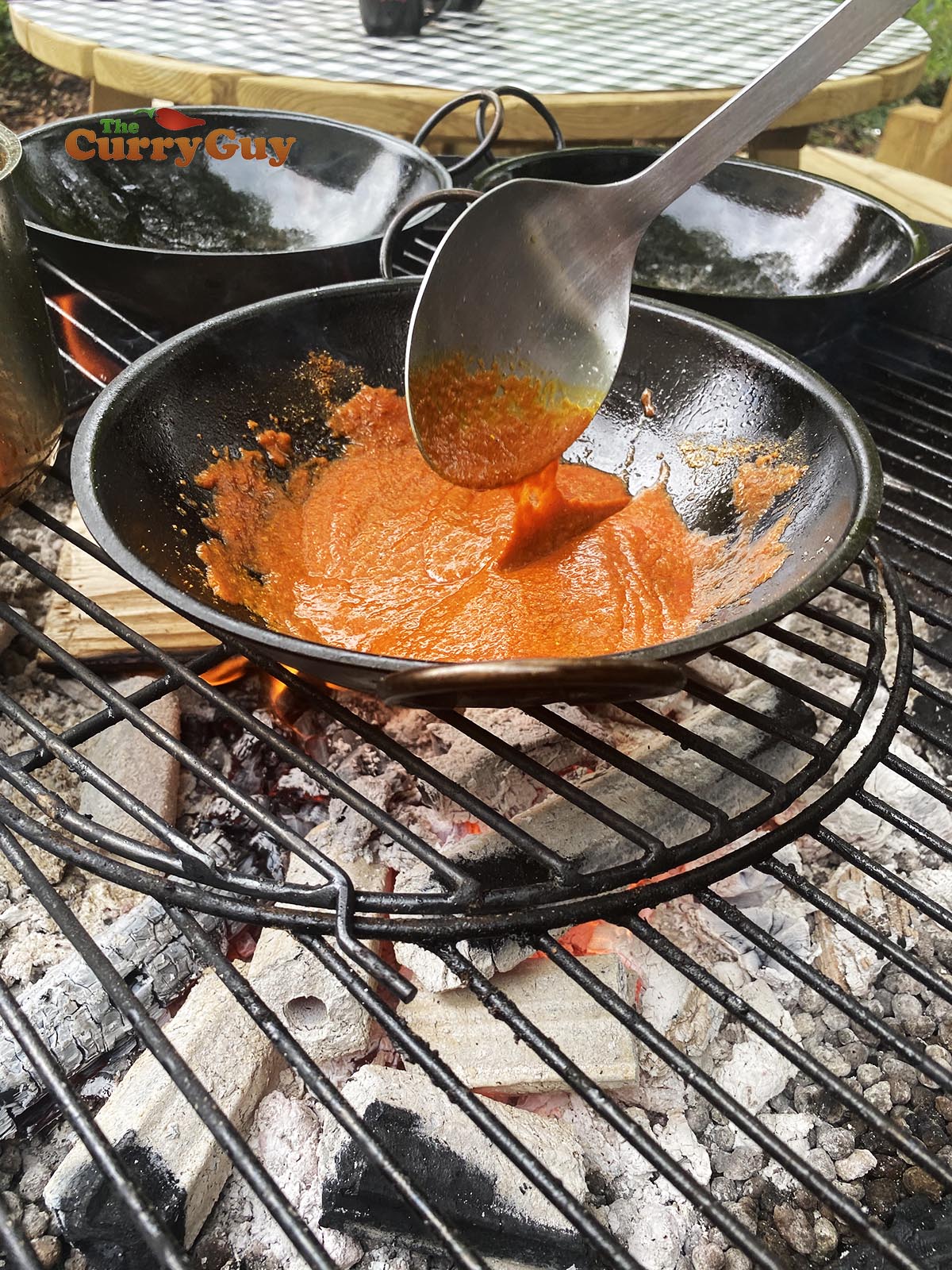 adding tomato puree to sauce.