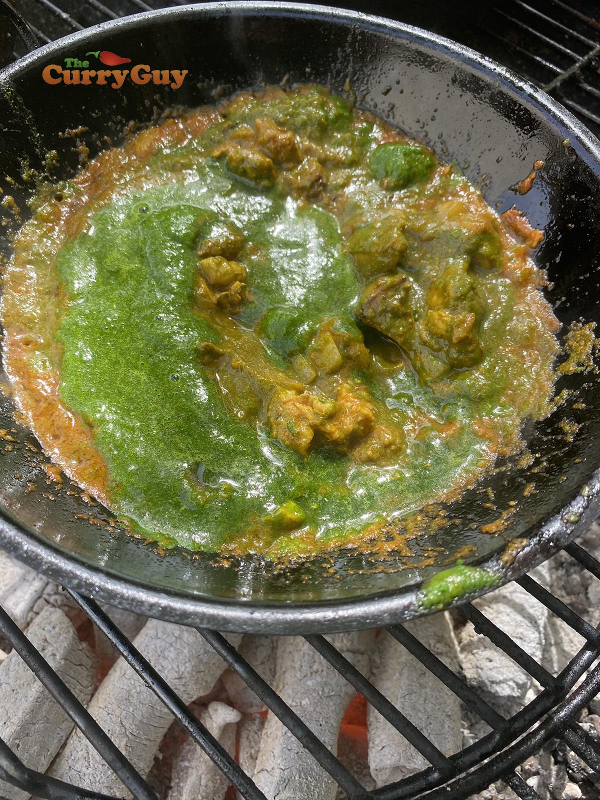 Adding blended spinach mixture to balti bowl