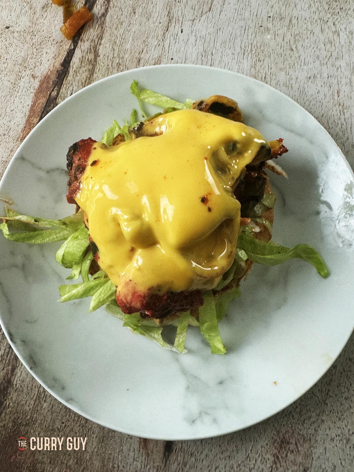 Adding one of the mounds of chicken and cheese to the bottom bun.
