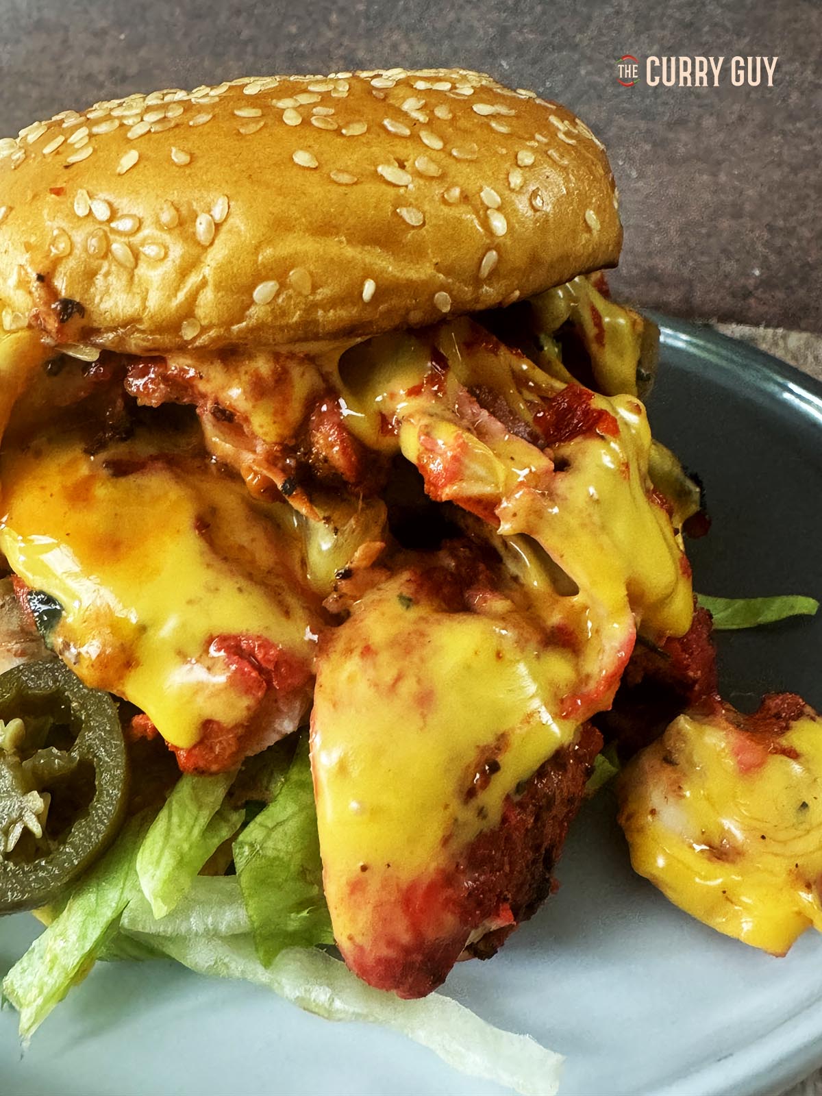 Tandoori chicken burger served on a serving plate.