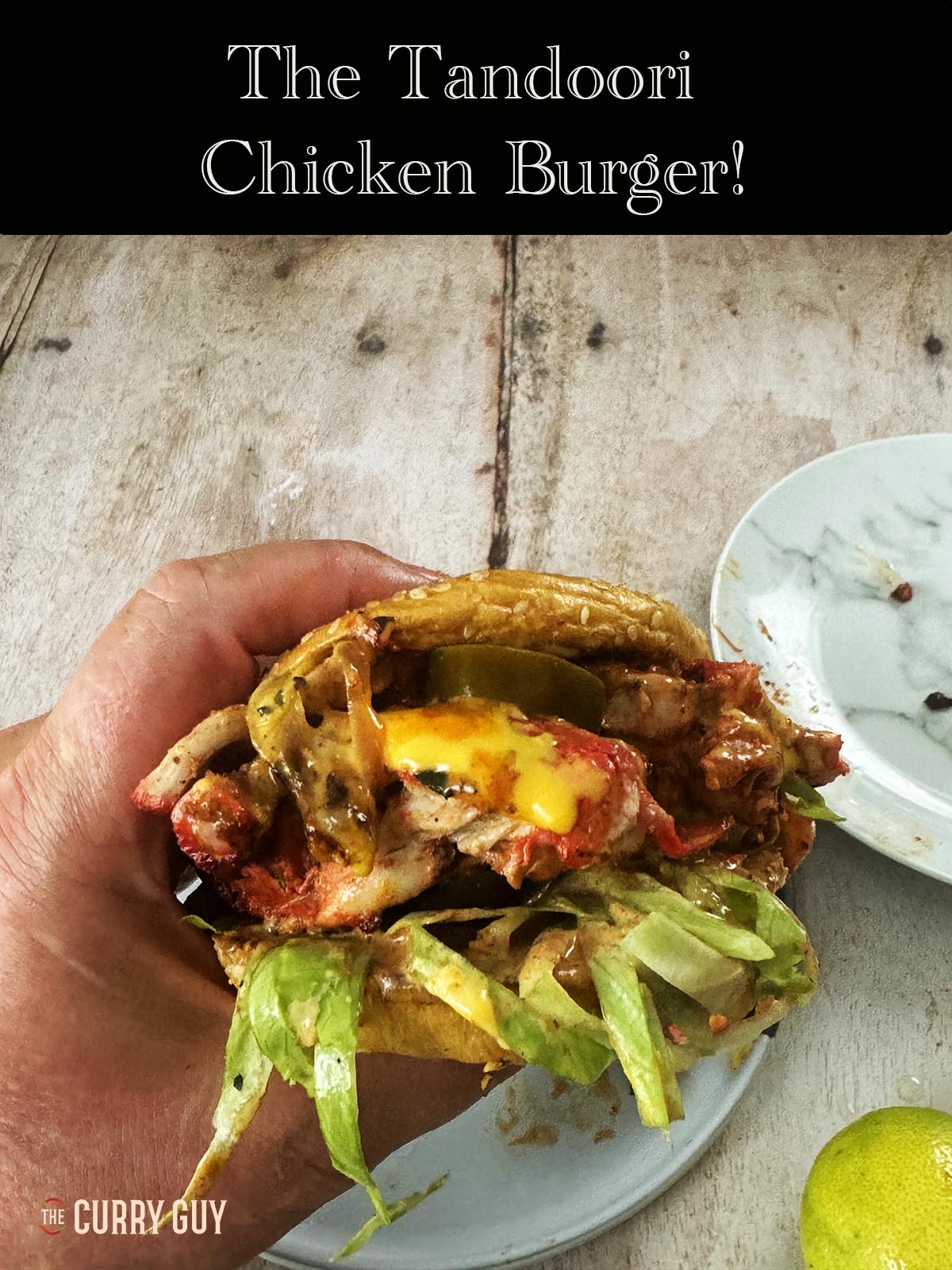 Eating the tandoori chicken burger. Side view of the burger.