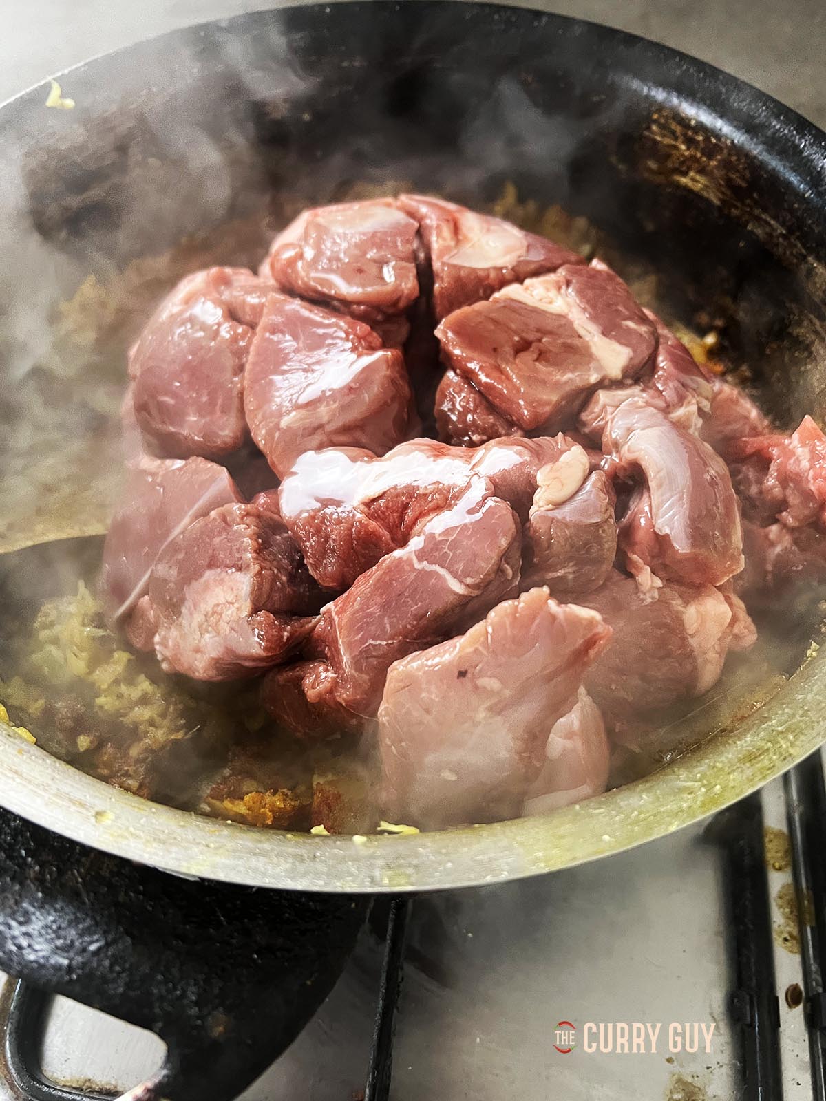 Adding the meat to the pan.