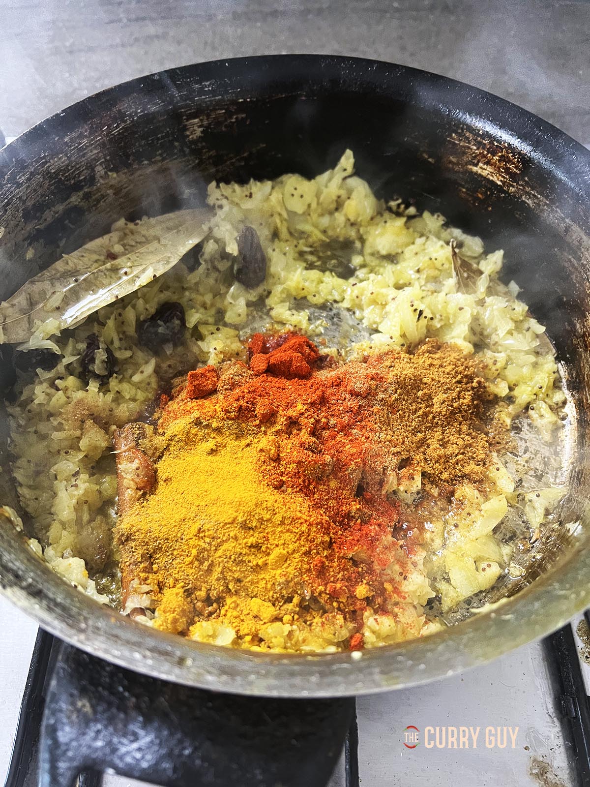 Adding the ground spices to the pan.