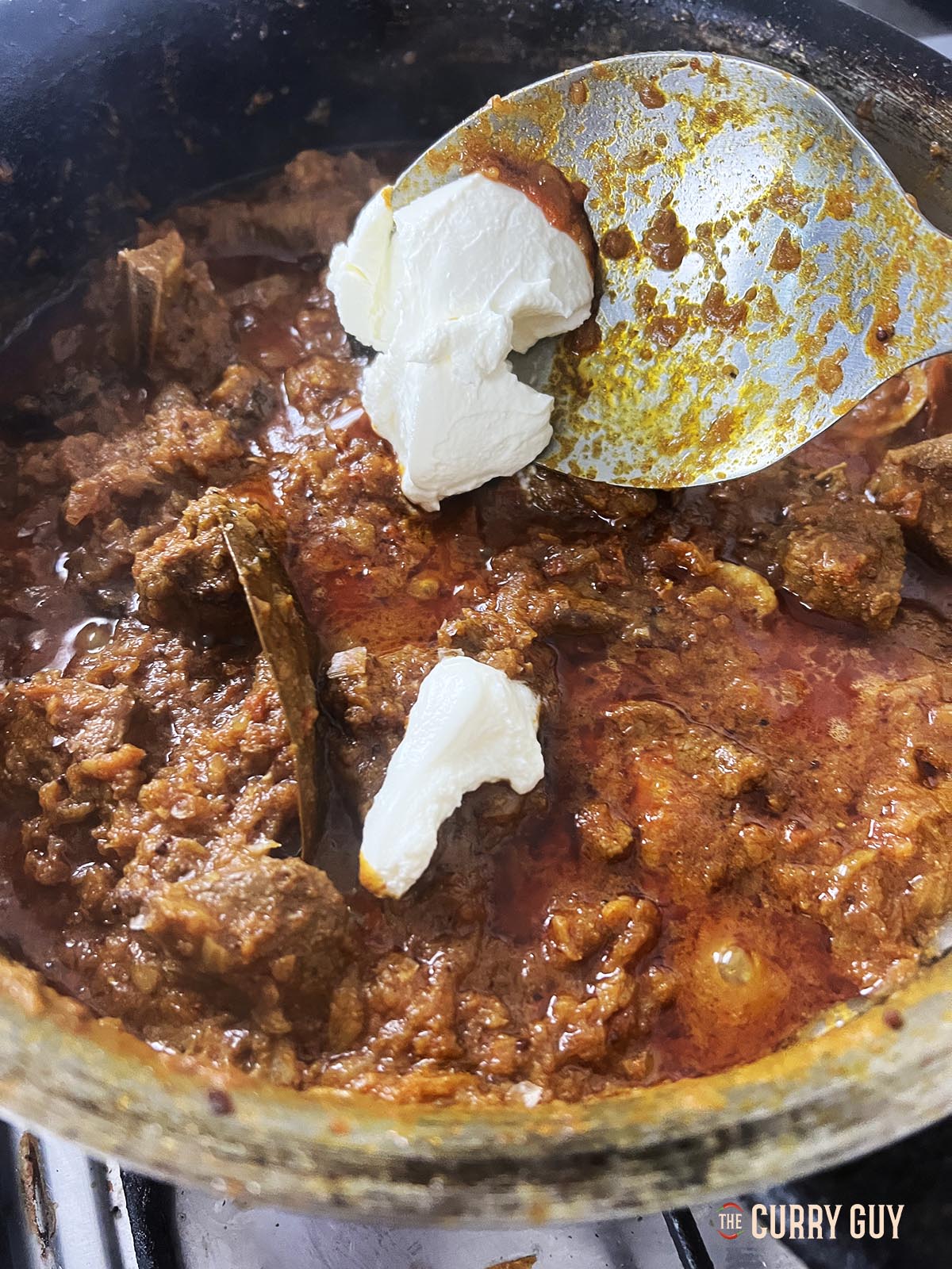 Adding yoghurt and salt to finish off the bhuna.