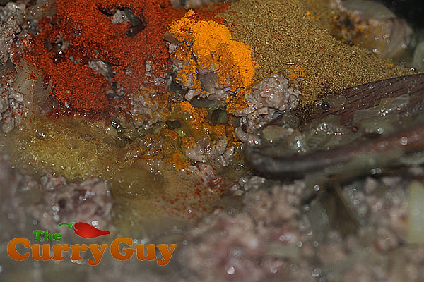 Adding spices to lamb keema saag