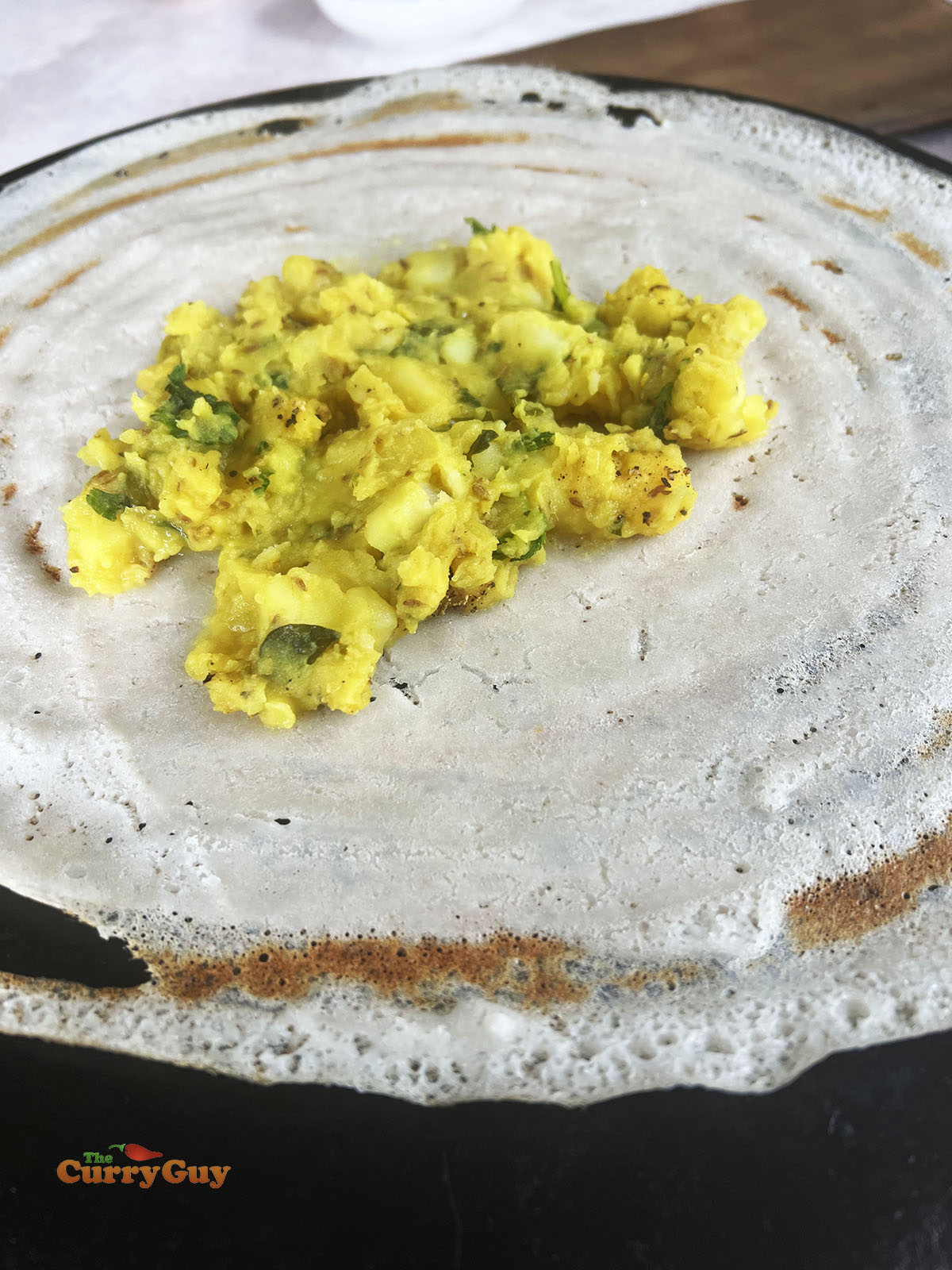 Adding the masala potatoes to the dosa