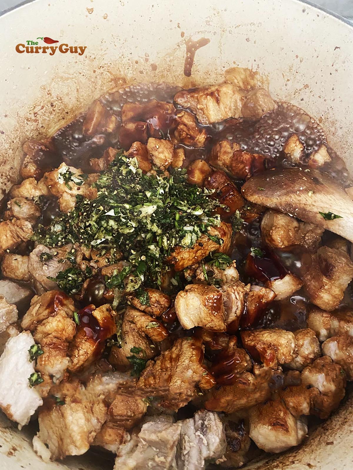 Returning the meat to the pan with the herb and pepper paste.