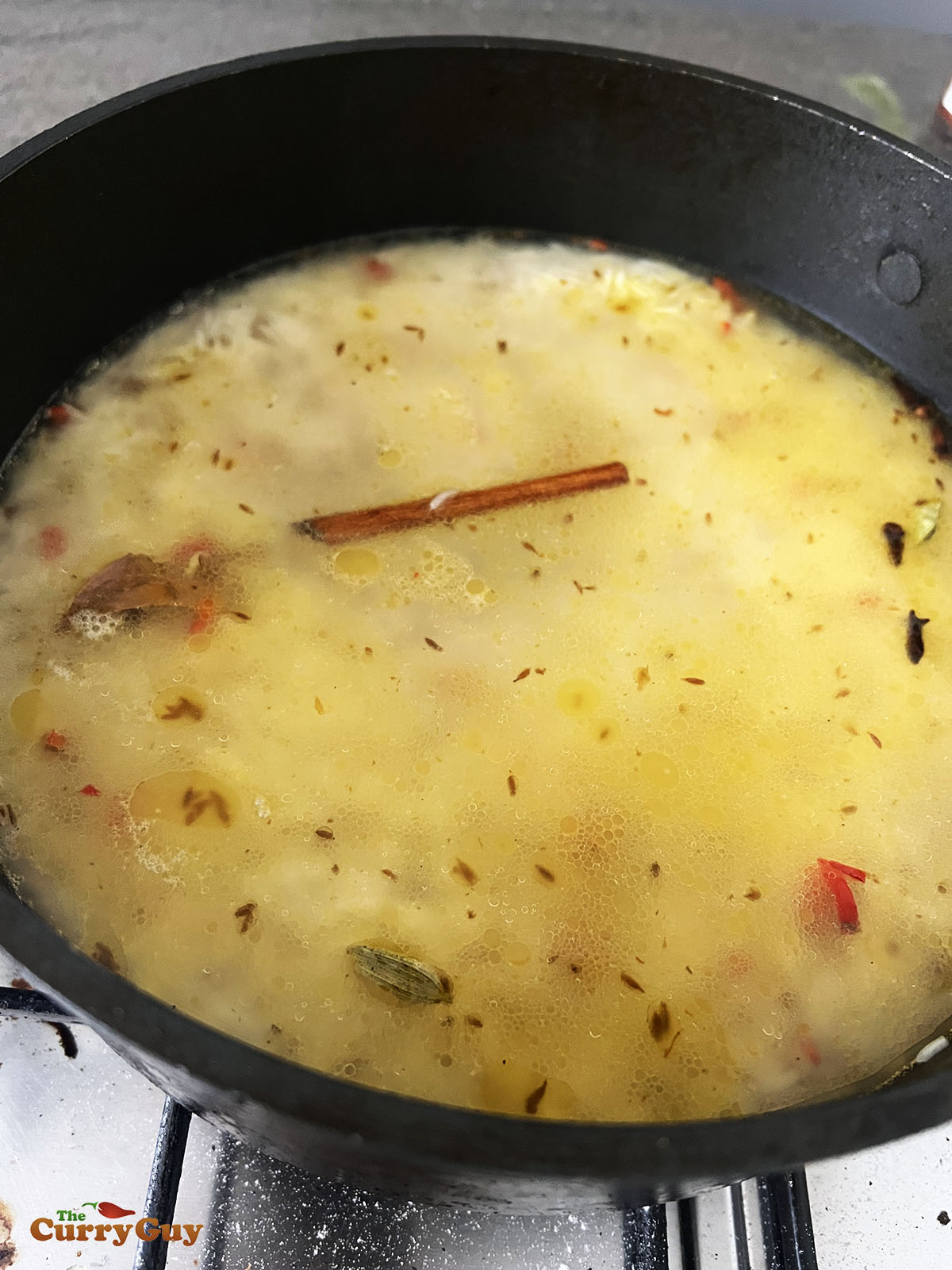 Adding water to the pan to cook the rice.